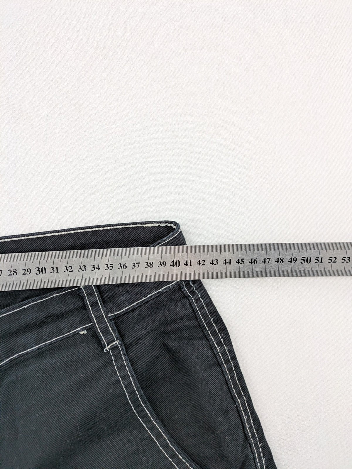 FSBN black baggy cargo pants with white contrast stitching and multiple pockets.