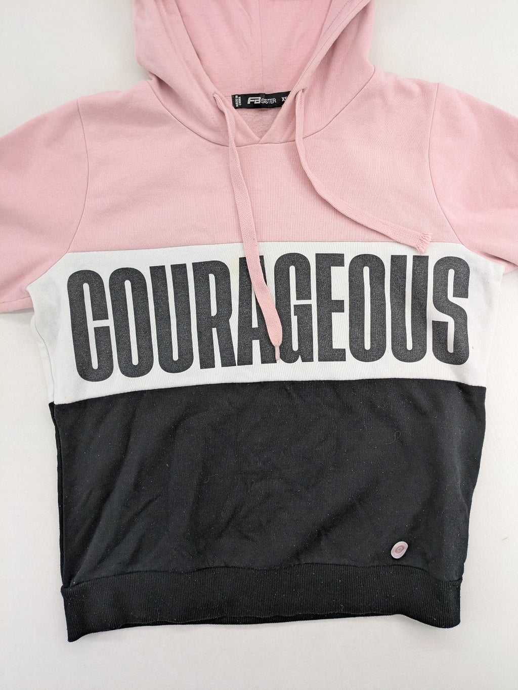FB Sister multi hoodie colorblock design pink, white, black with "COURAGEOUS" graphic print.
