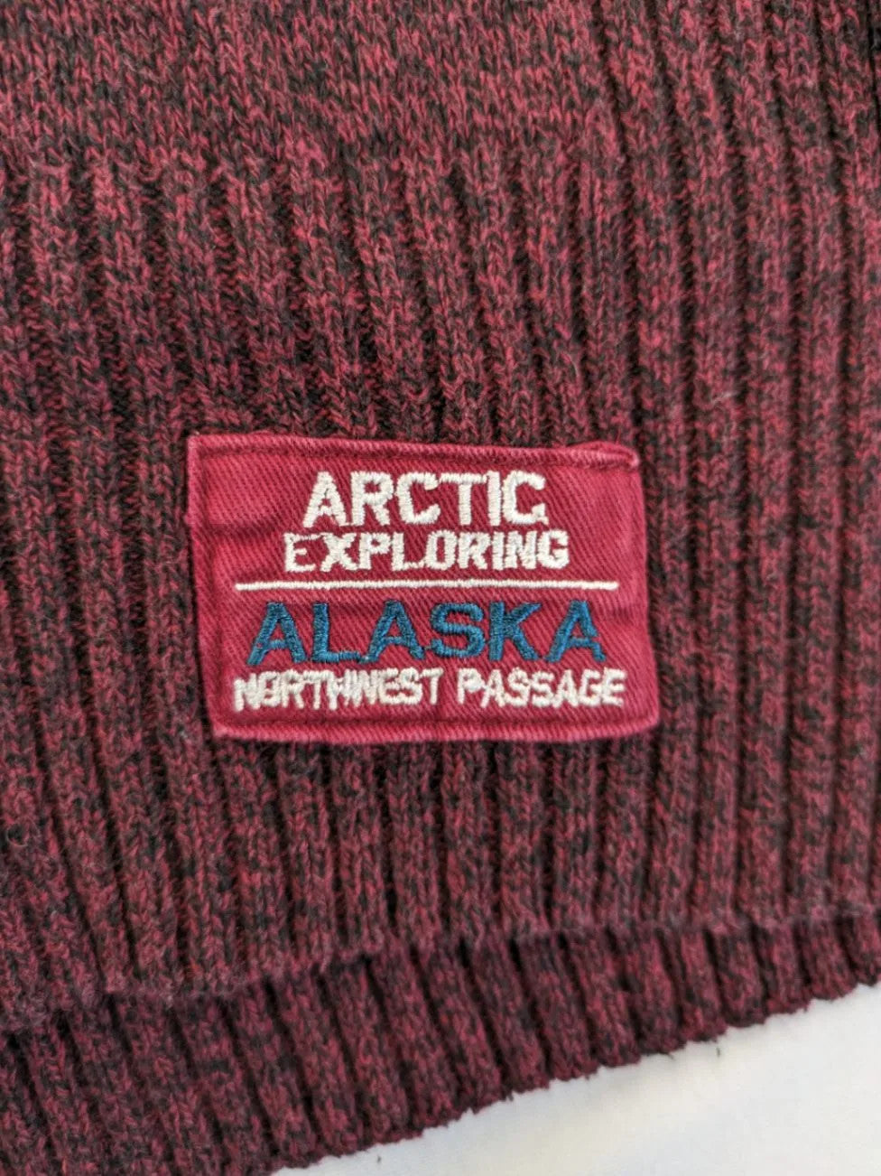 Infinity burgundy turtle neck jumper with quarter-zip and ribbed knit texture.