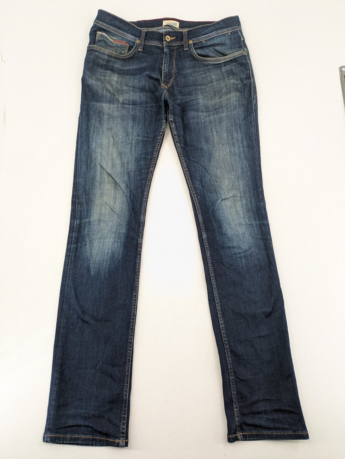 Tommy Hilfiger Denim blue straight jeans with five-pocket design and natural fading details.