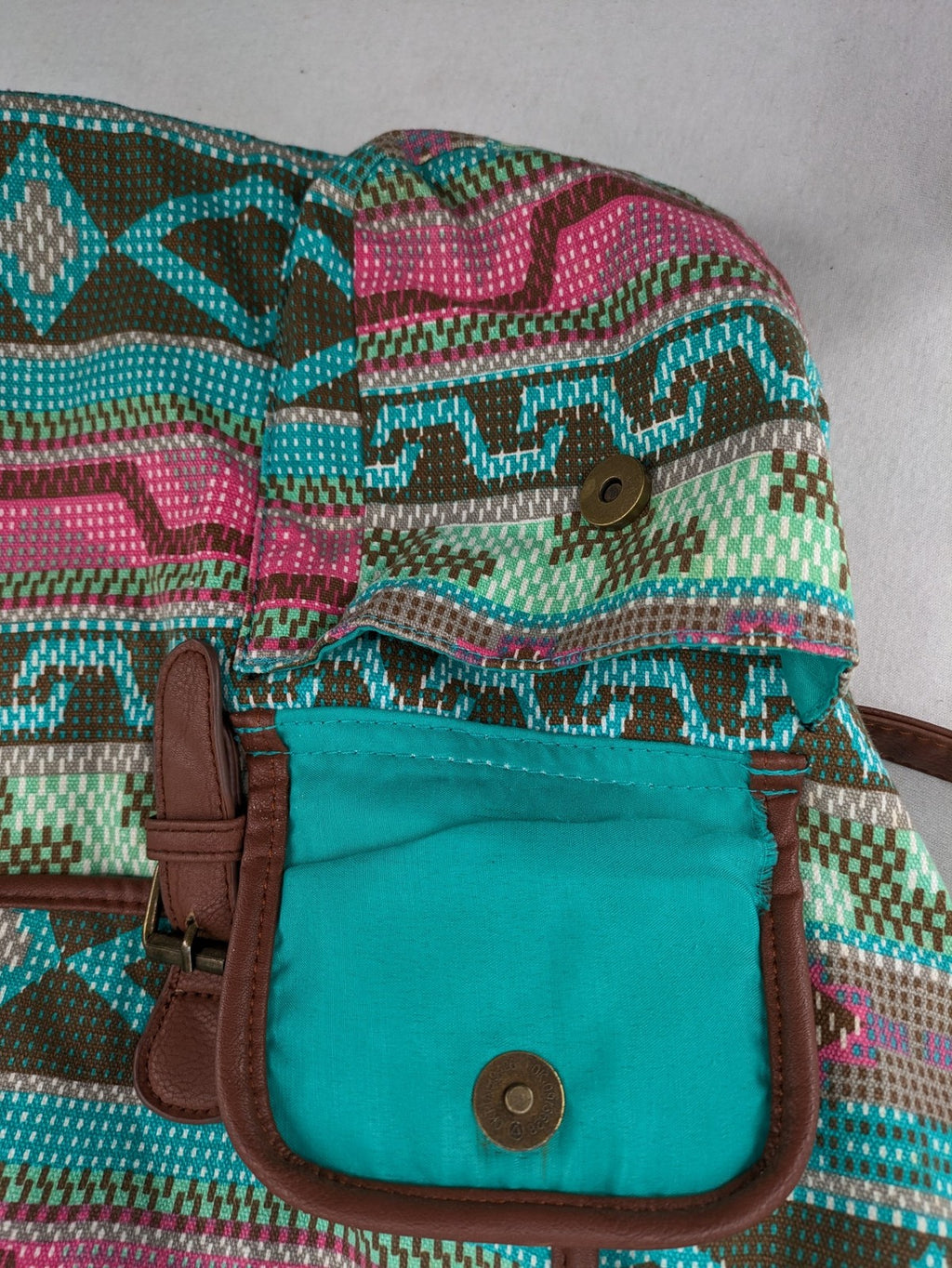 Boho multi backpack with vibrant Aztec tribal print and brown faux leather accents.