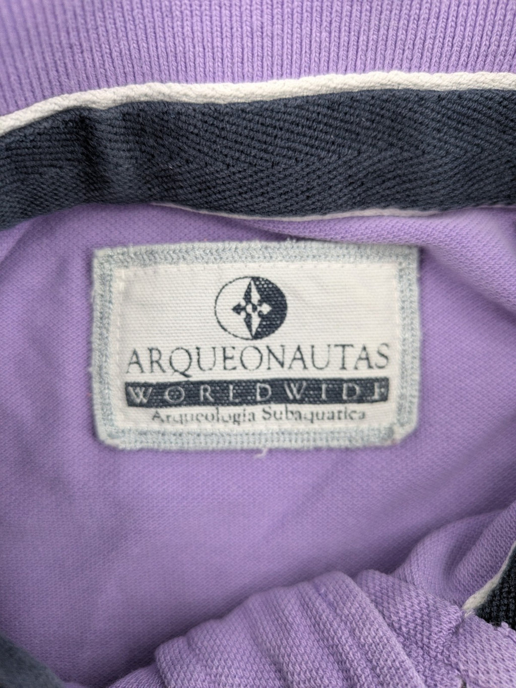 Arqueonautas purple polo shirt, short sleeves, embroidered logo, 100% cotton.