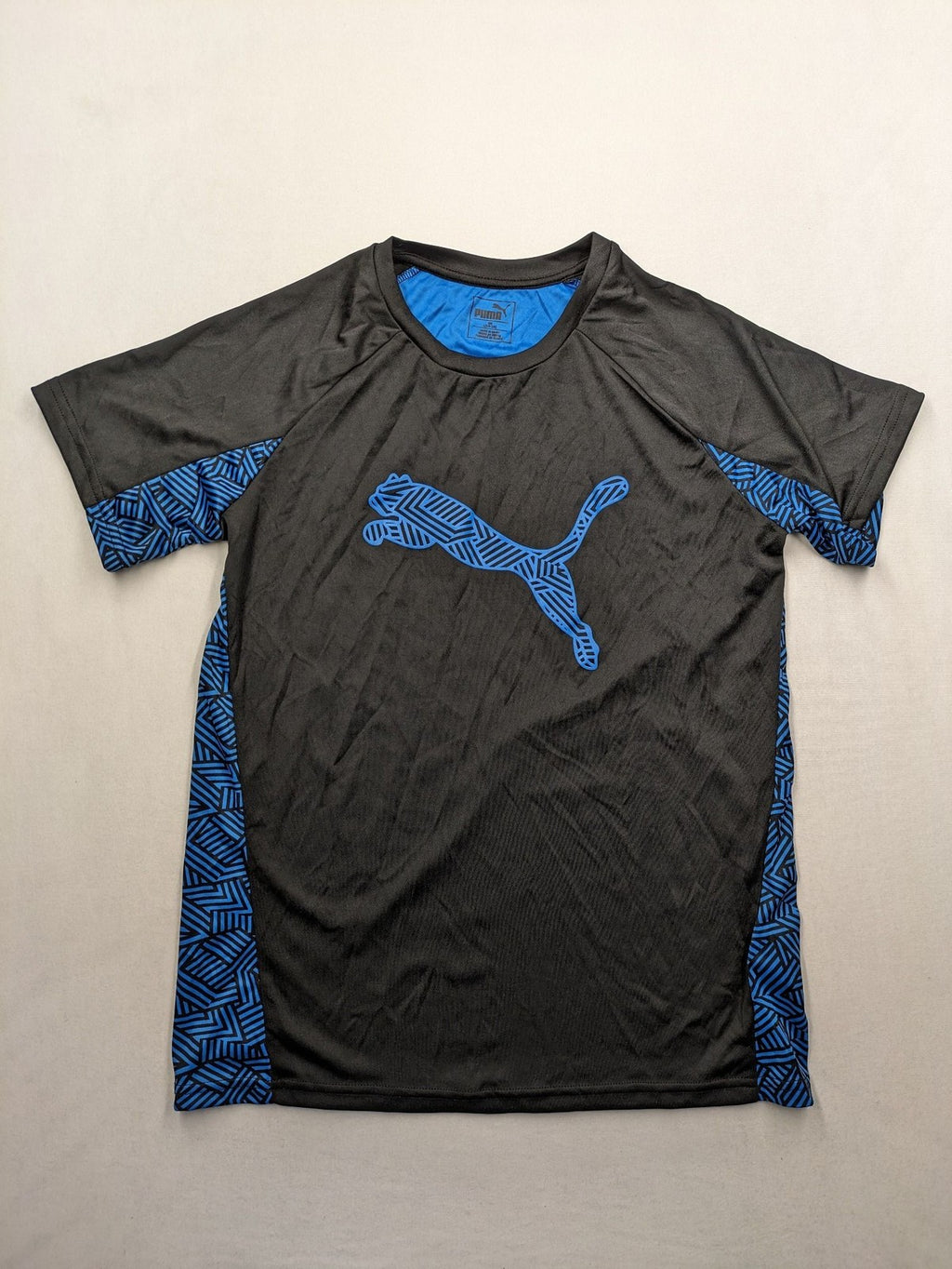 Puma black performance T-shirt with blue geometric side panels and iconic logo.