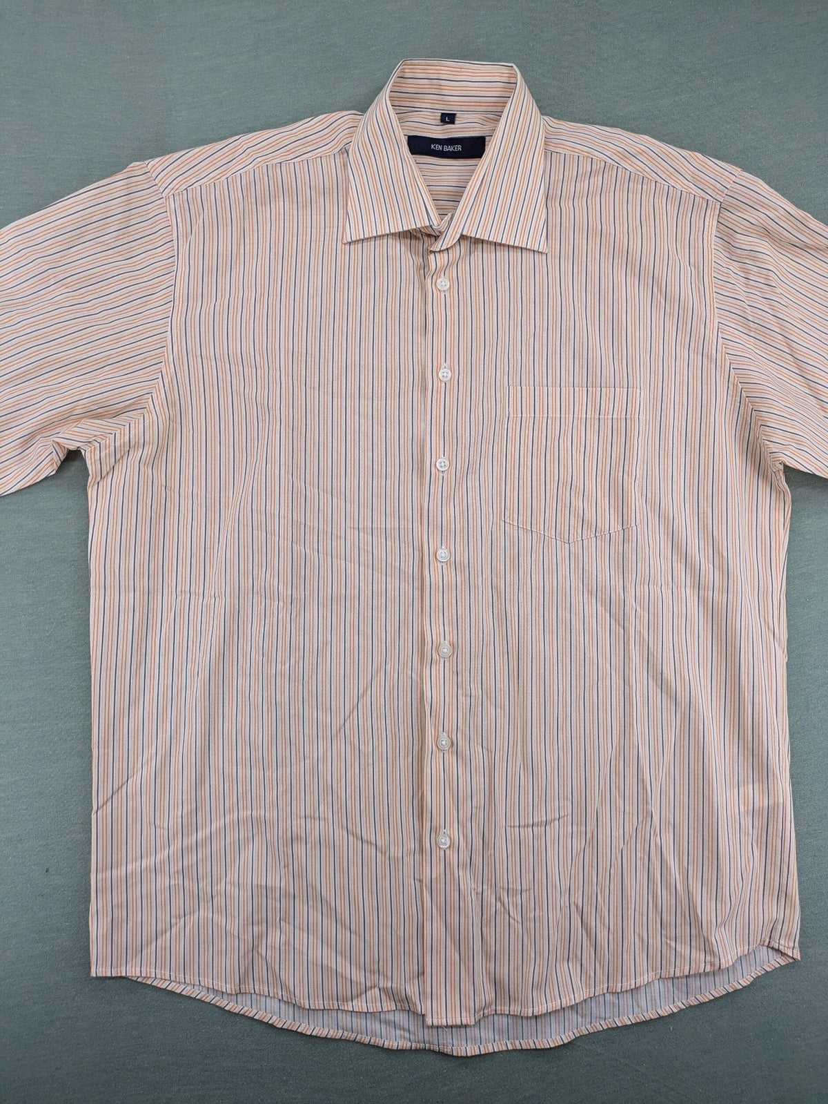 Ken Baker orange short-sleeve shirt with vertical stripes and chest pocket.