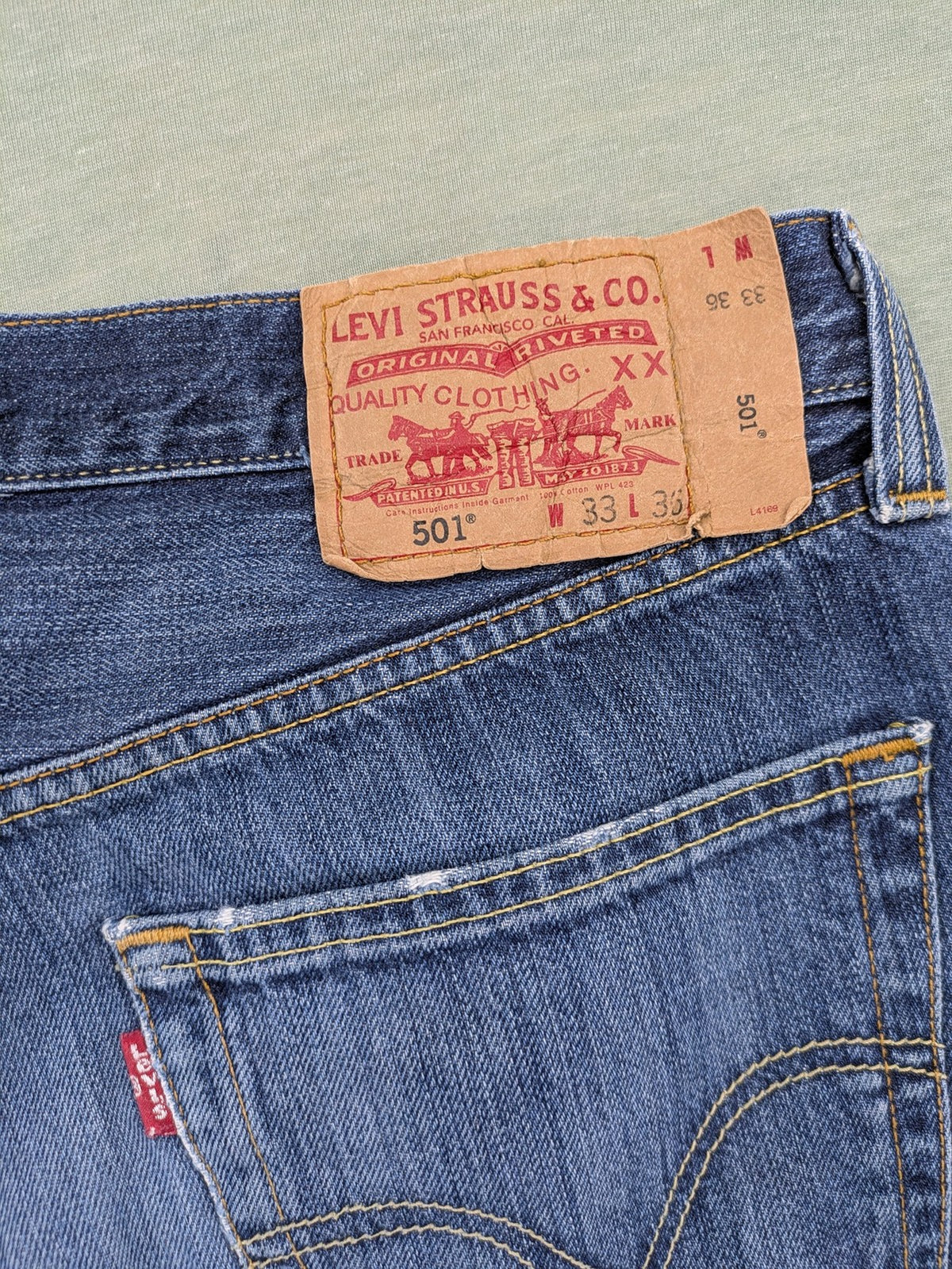 Levi's blue cut-off shorts with frayed hem, classic 5-pocket design, button fly.