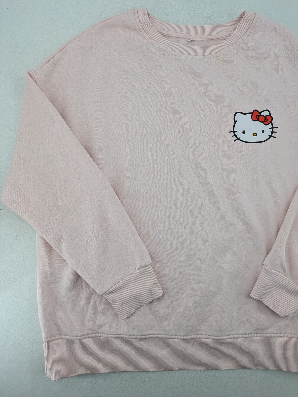 Hello Kitty pink sweatshirt classic graphic face logo on chest, long sleeves, round neck.