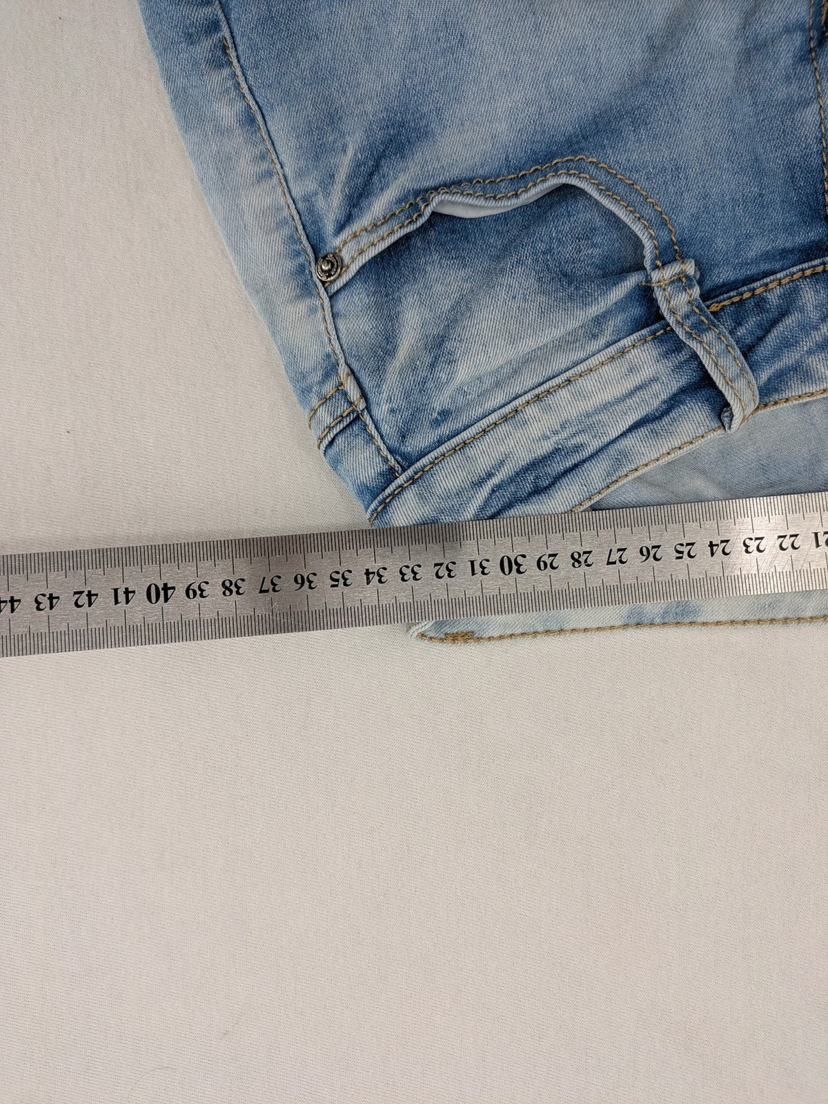 Lexxury blue skinny jeans distressed with knee rips and light wash finish.