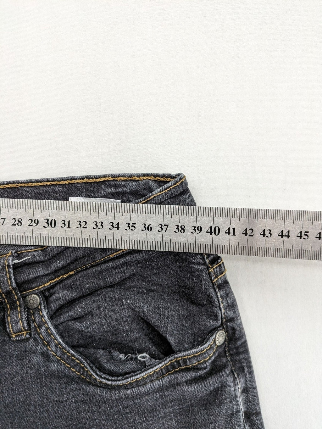Bootcut grey low rise bootcut jeans five-pocket design with zipper and button closure.