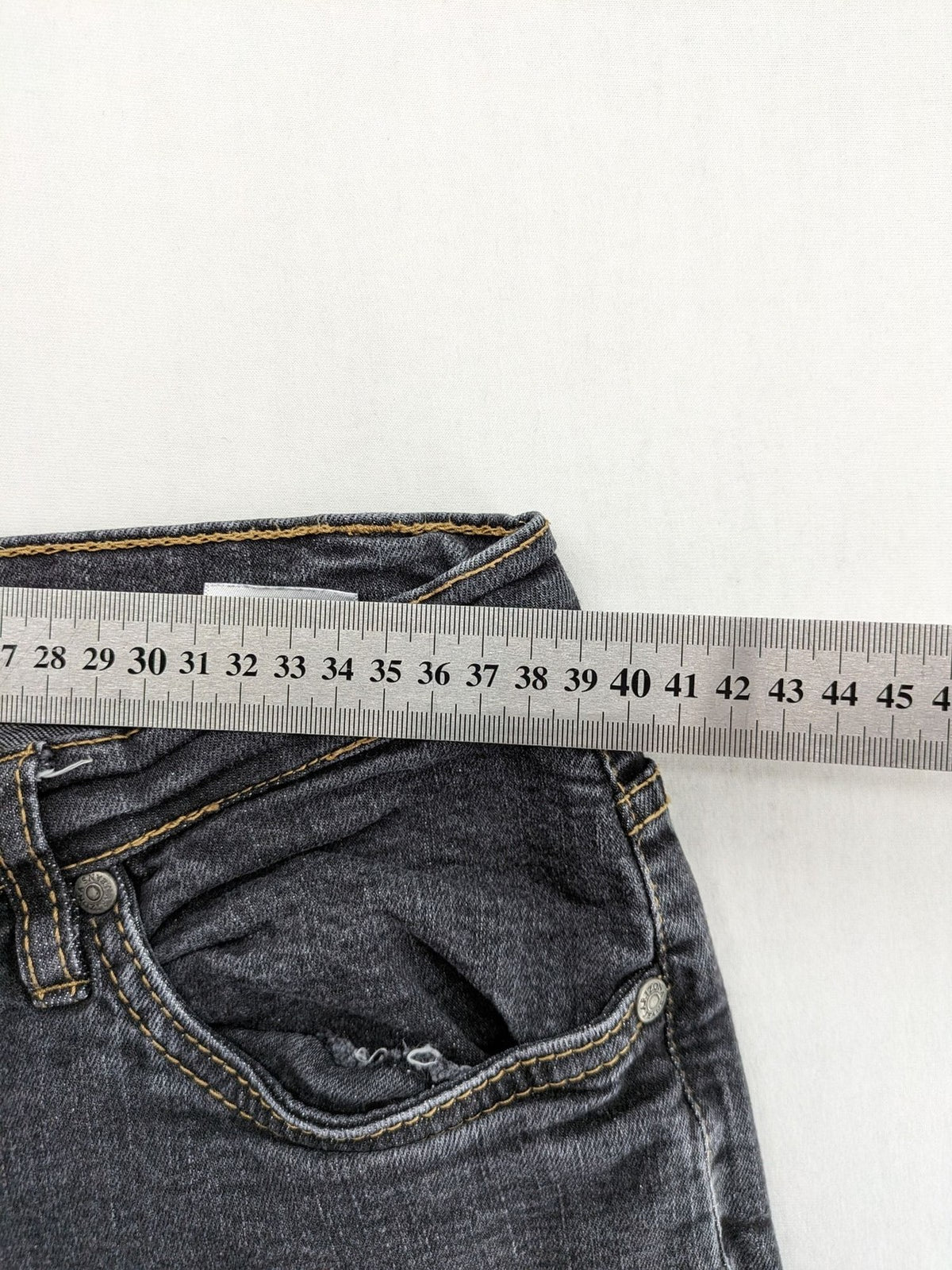 Bootcut grey low rise bootcut jeans five-pocket design with zipper and button closure.