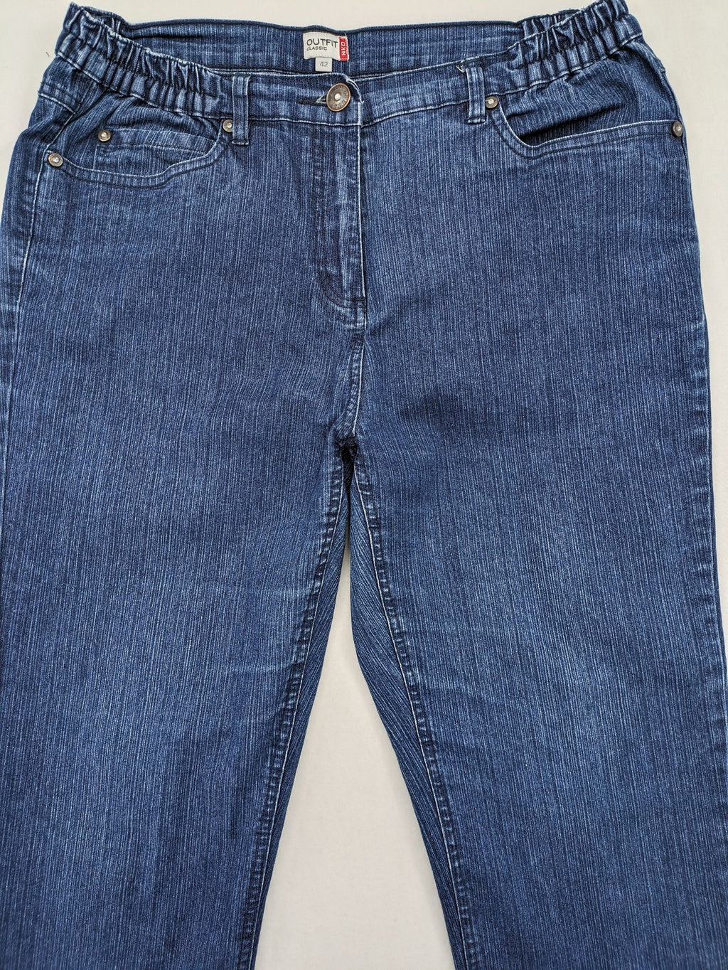 Outfit blue straight jeans with elastic waistband and embroidered crown-wing emblem on pockets.