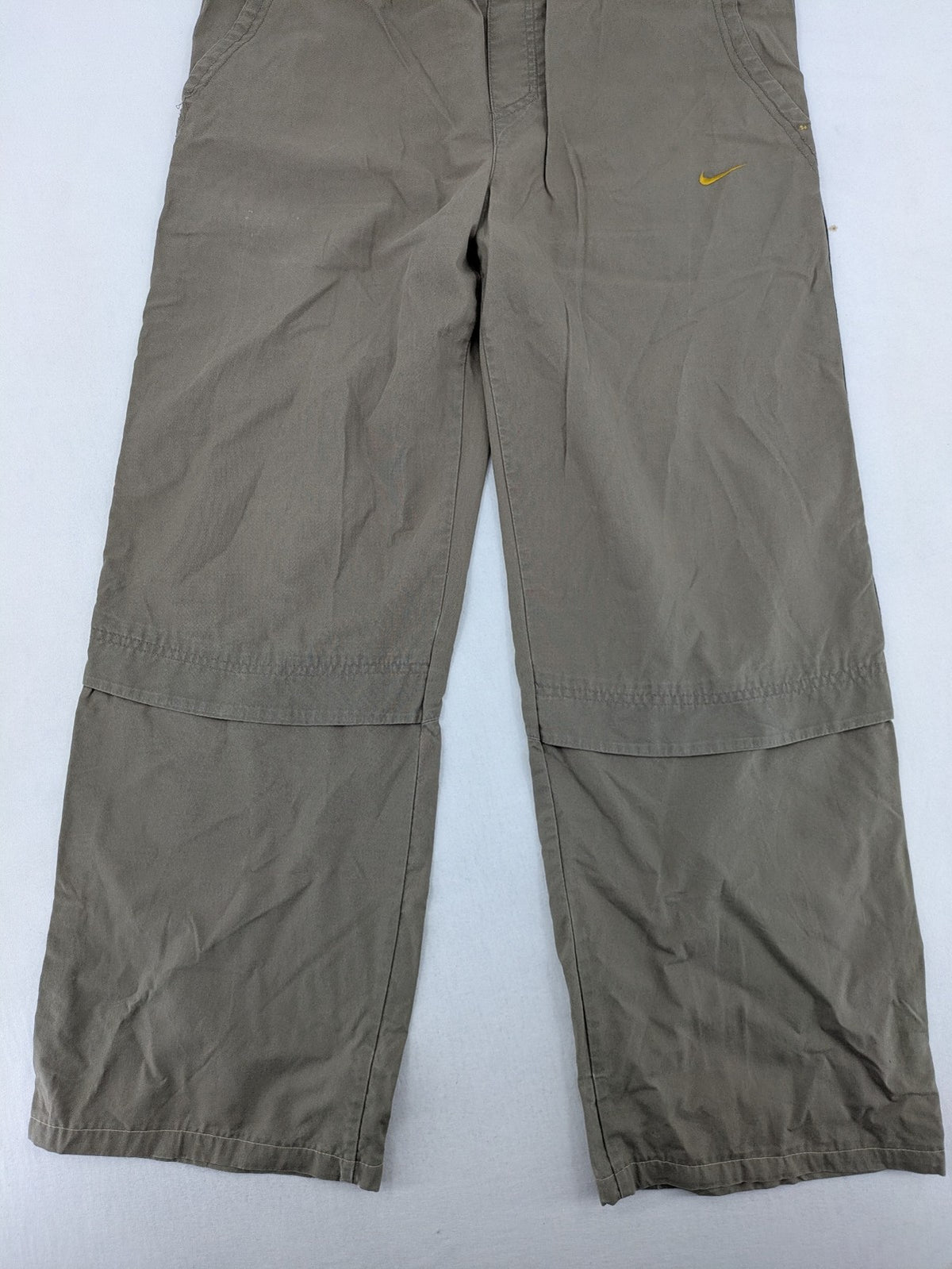Nike khaki training pants with logo, elastic waistband, and practical pockets.