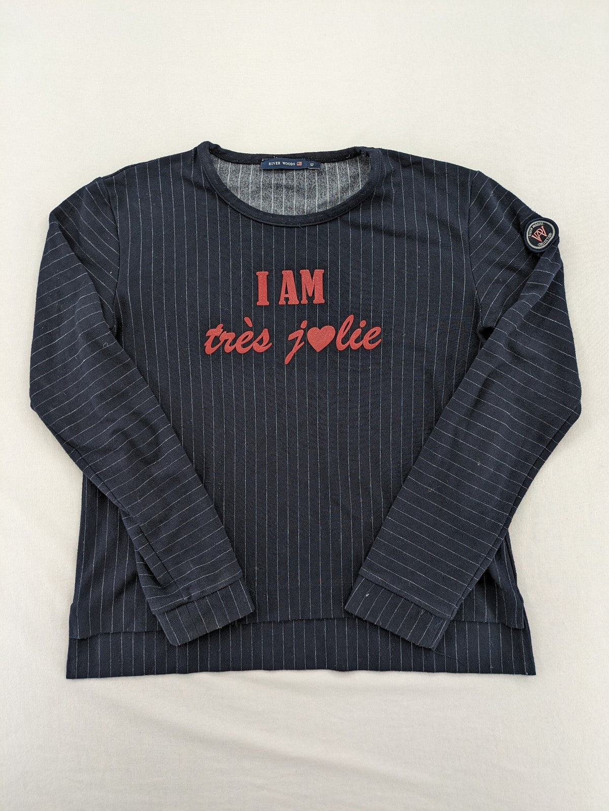 RIVER WOODS navy long sleeve top with white pinstripes and red "I AM très jolie" slogan.