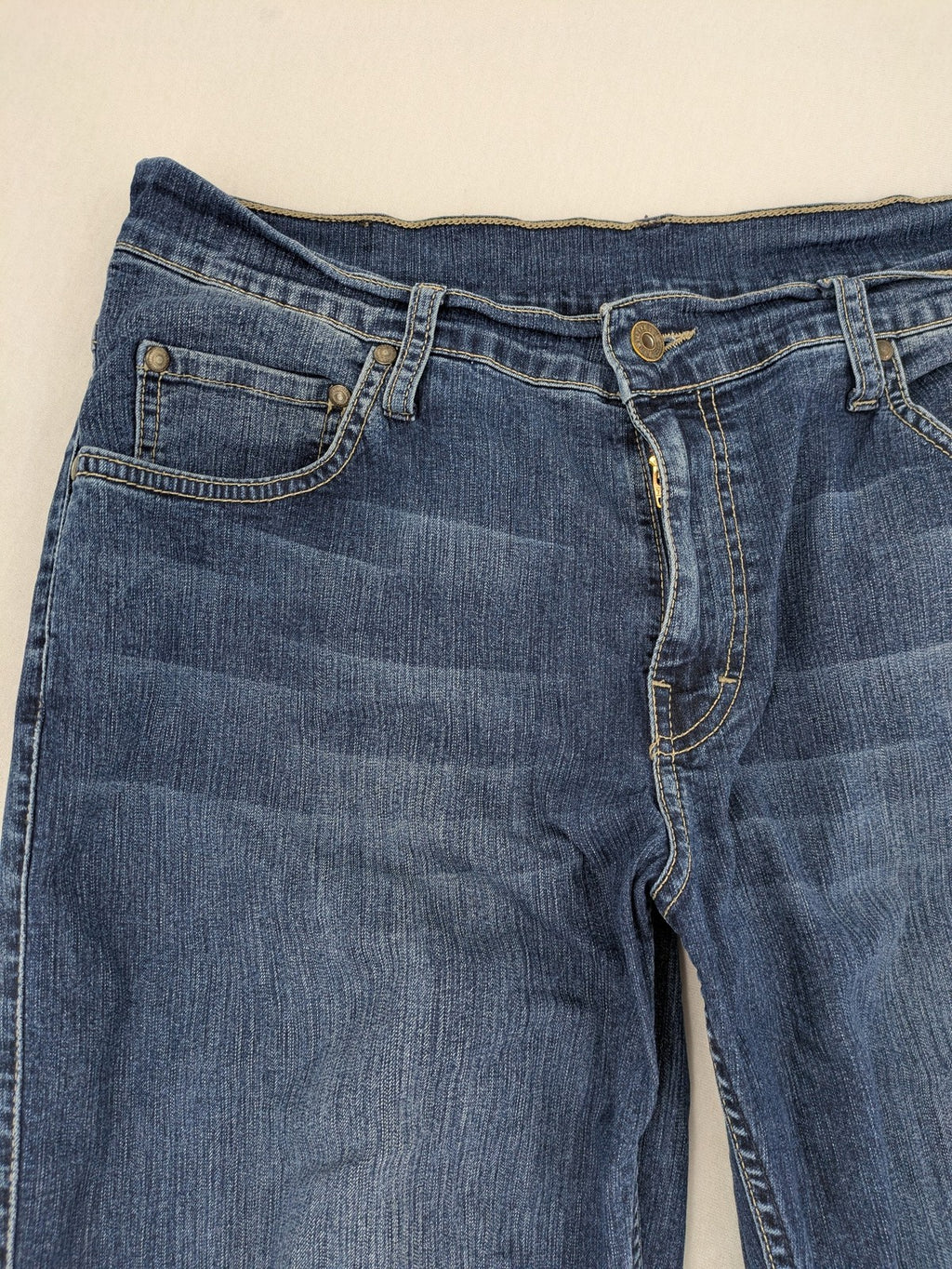 Mustang blue bootcut jeans with custom painted floral designs on both legs.