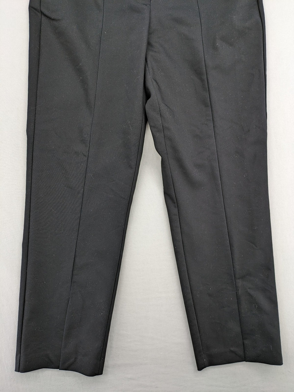 Zara black pants with front creases, subtle slit hem, and buttoned back pocket.