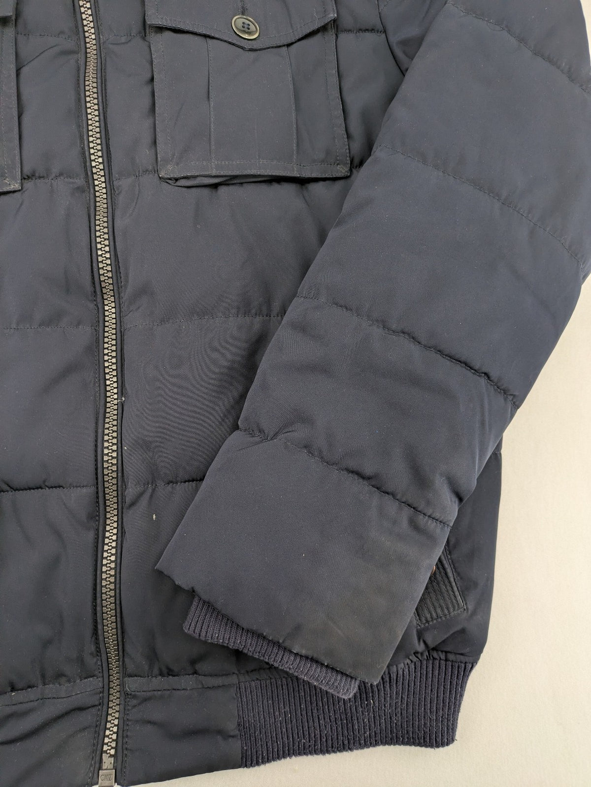 Tom Tailor navy puffer jacket with quilted design and adjustable hood, featuring multiple pockets.