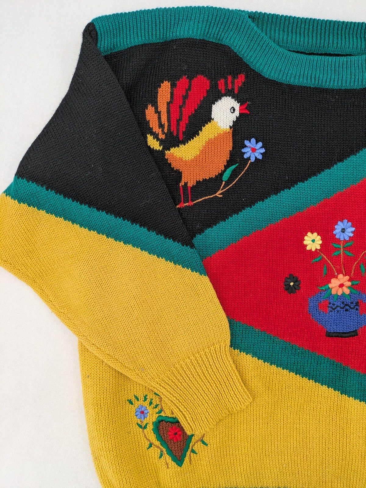 Pullover multi knit jumper featuring colorful block pattern and embroidered rooster and flowers.