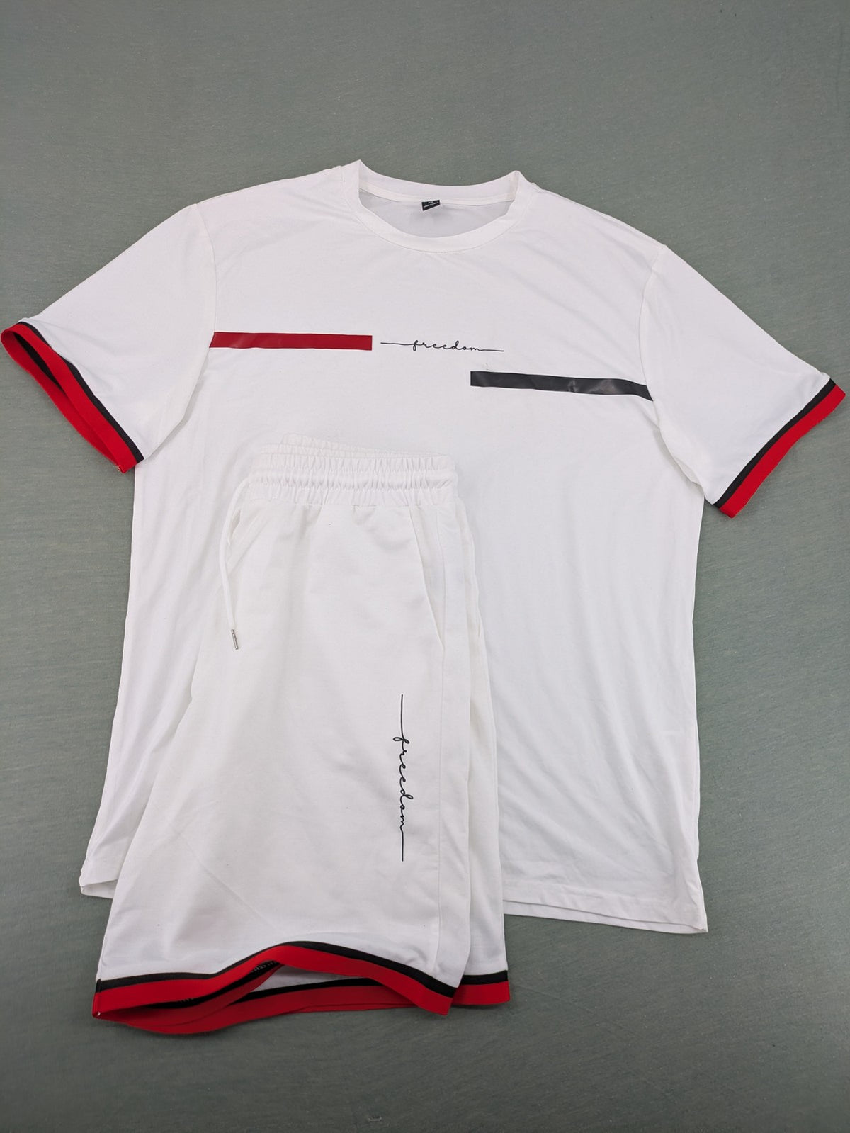 Manfinity black and white outfit set with red accents and "Freedom" graphic print.