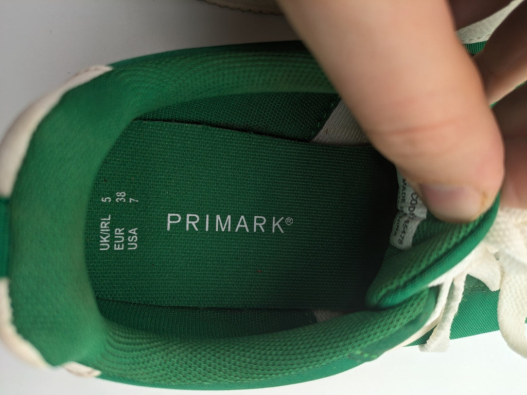 Primark green and white retro sneakers with classic lace-up design and textured rubber sole.