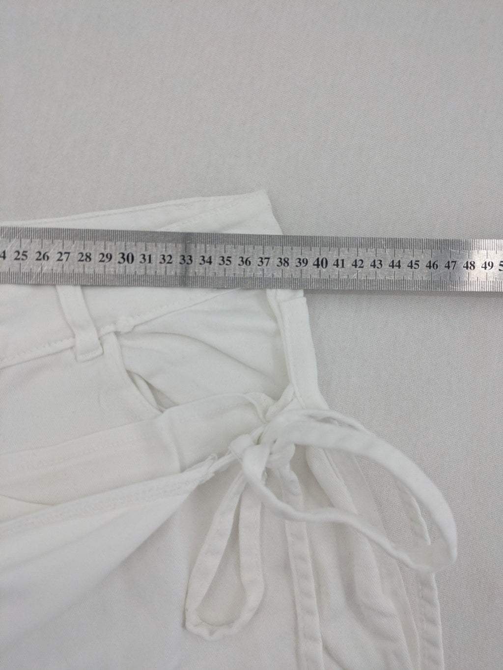 New Collection white straight jeans asymmetrical wrap design with side lacing and cotton-stretch material.