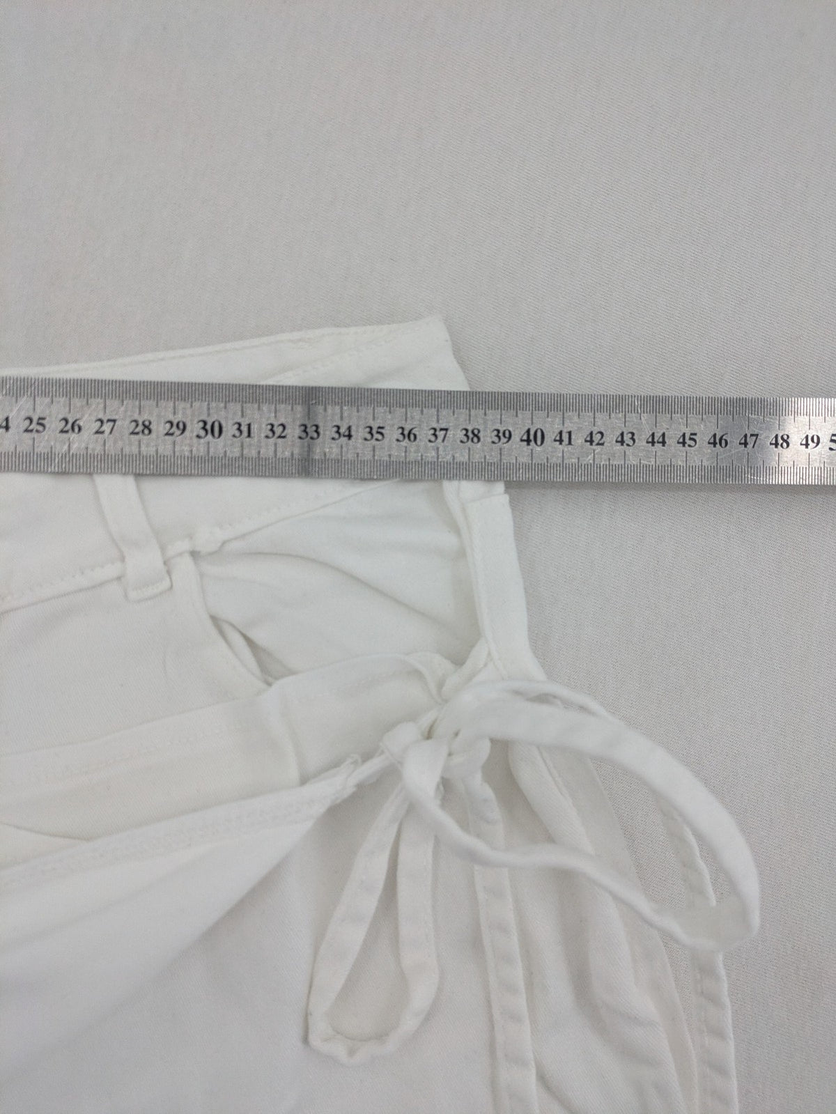 New Collection white straight jeans asymmetrical wrap design with side lacing and cotton-stretch material.