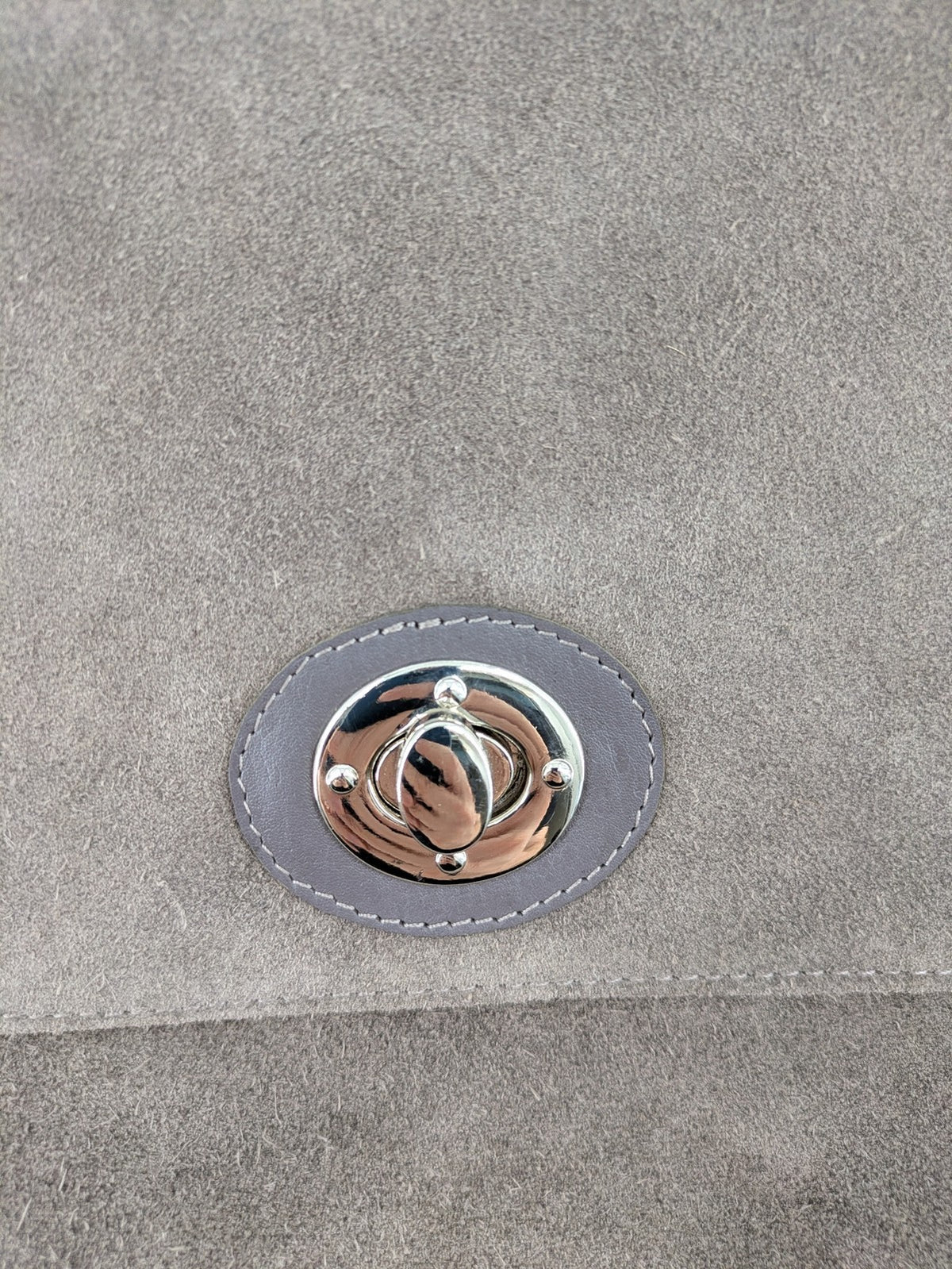 CNTMP grey suede crossbody handbag with flap and silver twist lock closure.