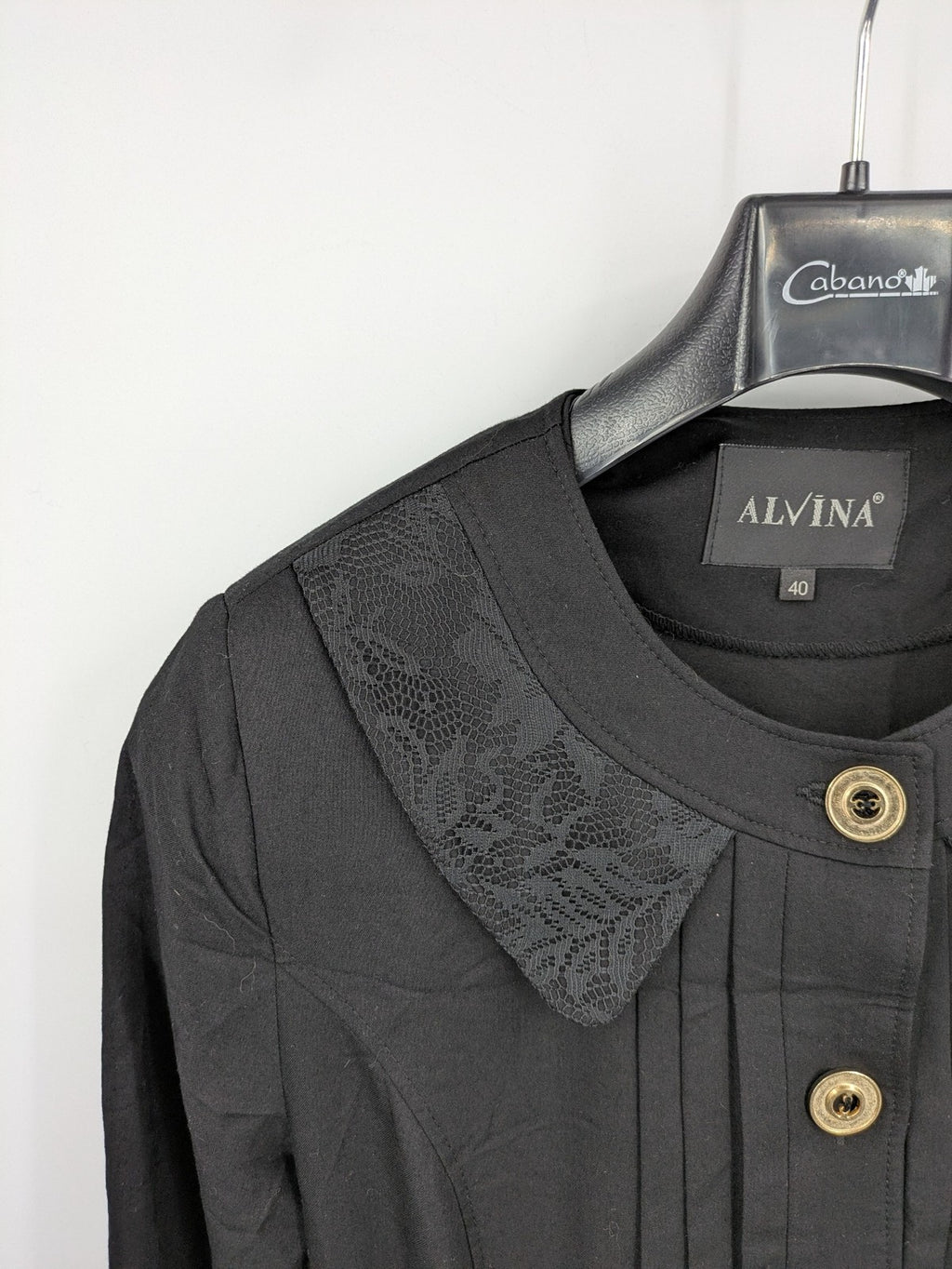 Alvina black trench coat with lace collar and gold buttons, belted waist design.
