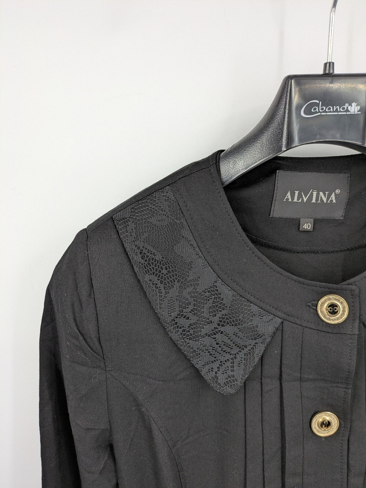Alvina black trench coat with lace collar and gold buttons, belted waist design.