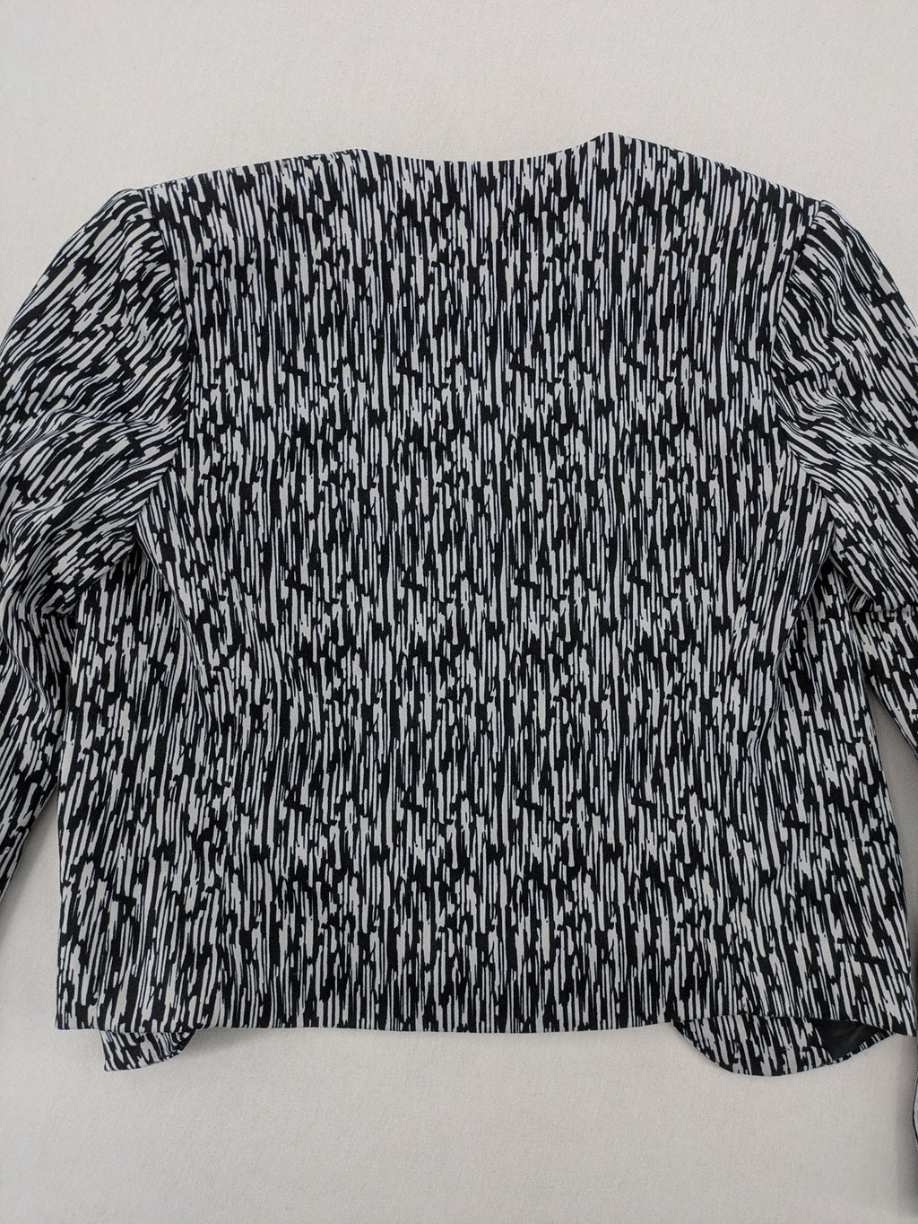 H&M Divided black and white patterned blazer with open front and two front pockets.