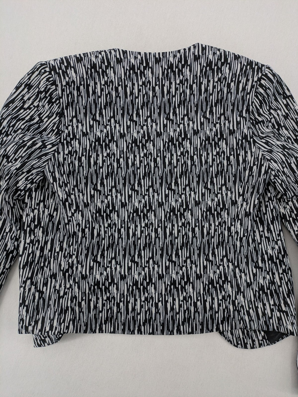 H&M Divided black and white patterned blazer with open front and two front pockets.