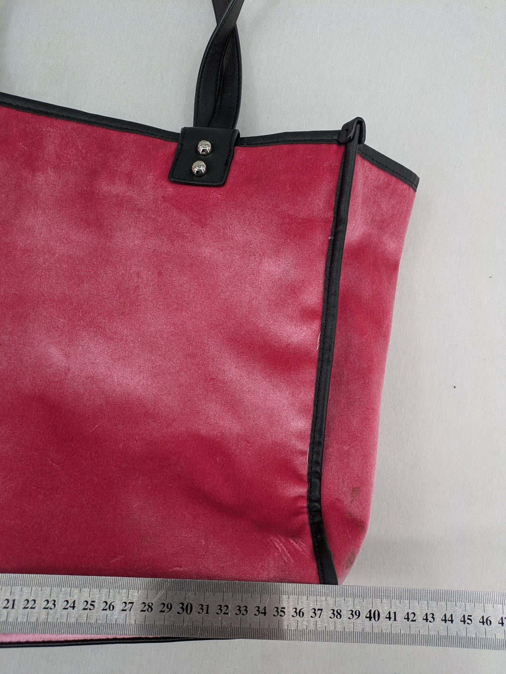 Juicy Couture pink velour handbag with oversized black logo and faux leather straps.