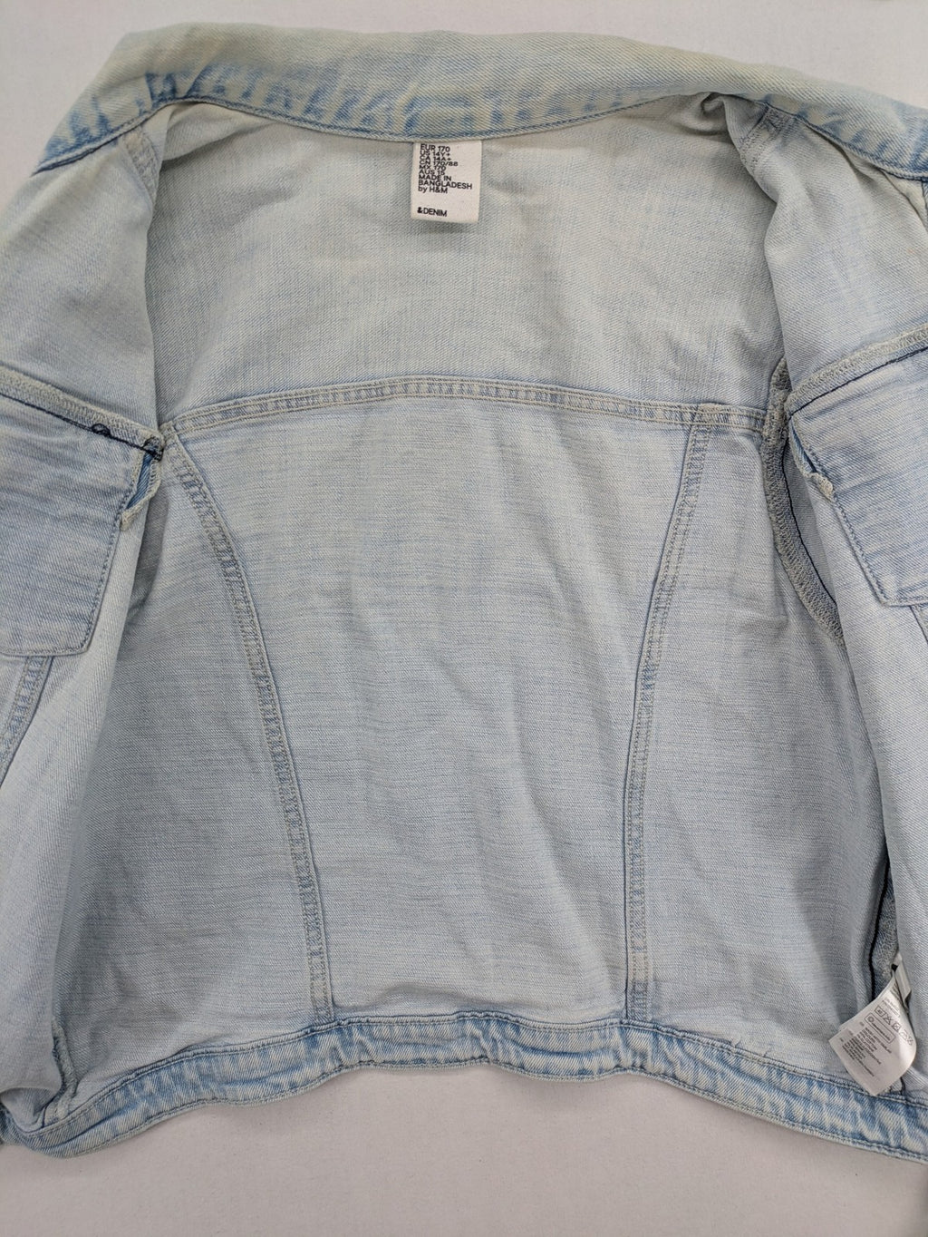 H&M denim jacket light blue classic trucker style with button placket and chest pockets.