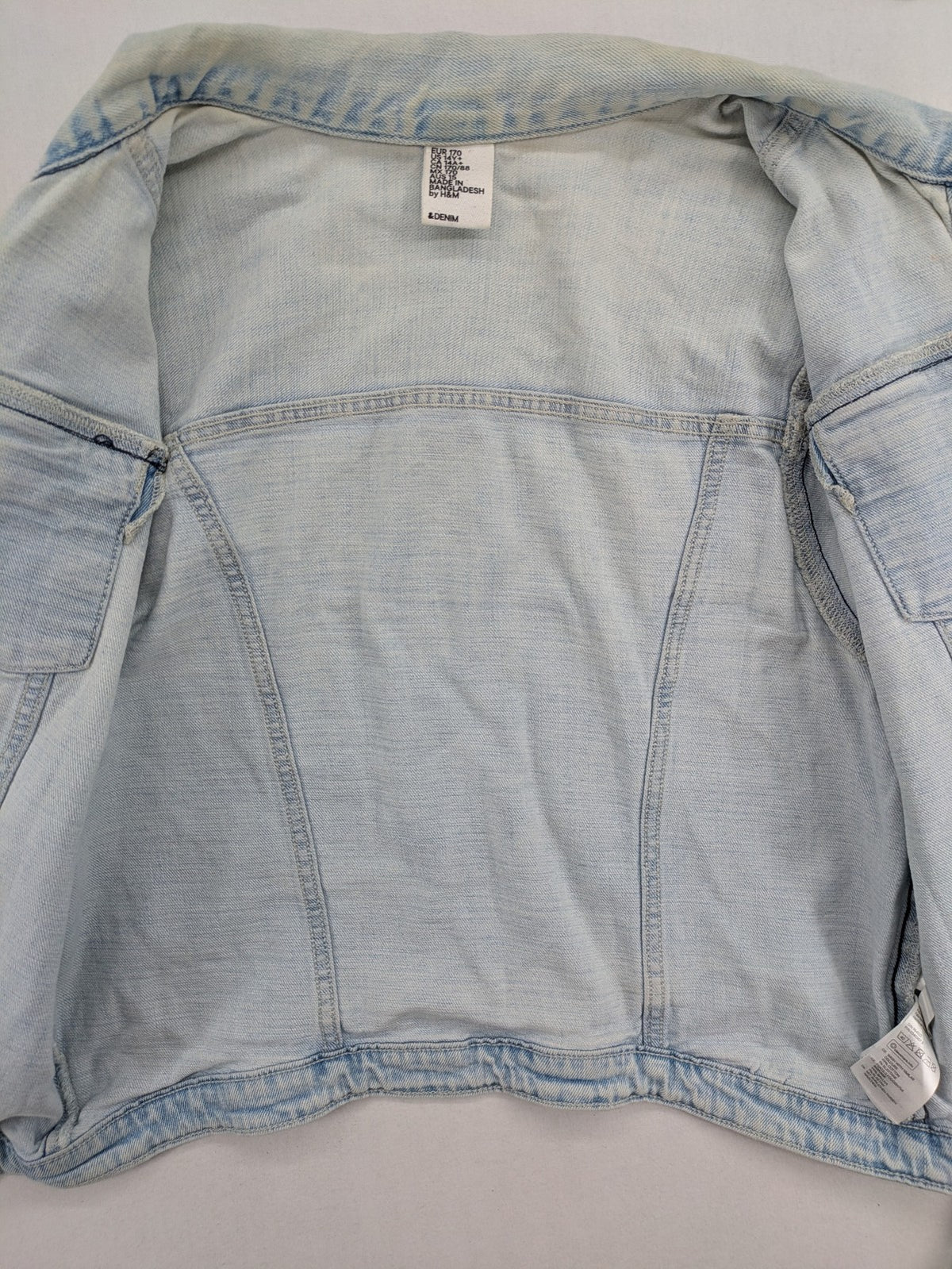 H&M denim jacket light blue classic trucker style with button placket and chest pockets.