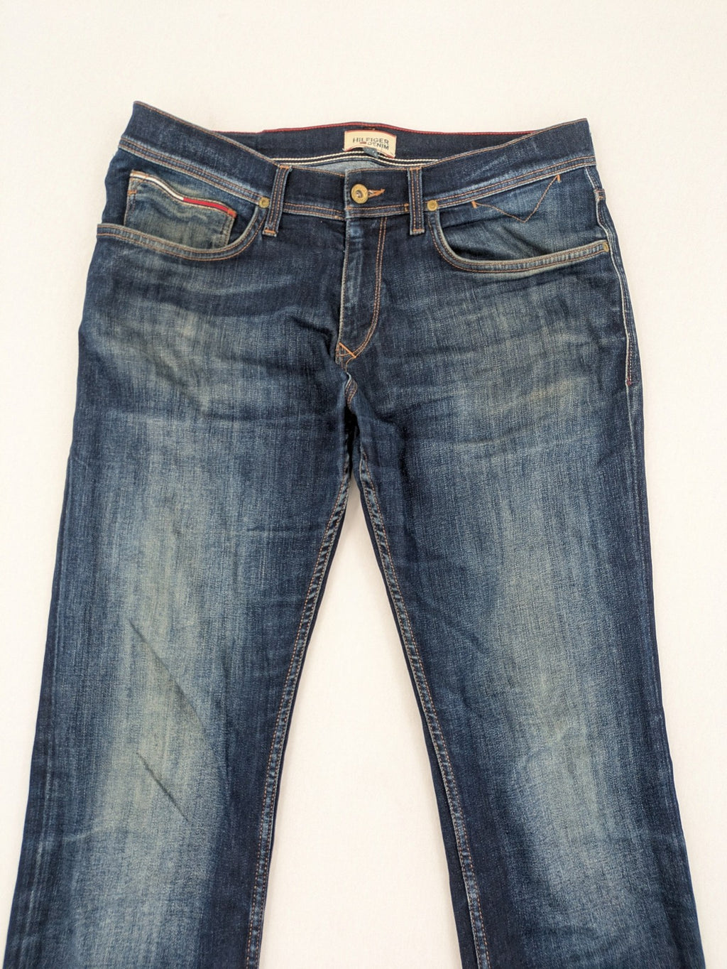 Tommy Hilfiger Denim blue straight jeans with five-pocket design and natural fading details.