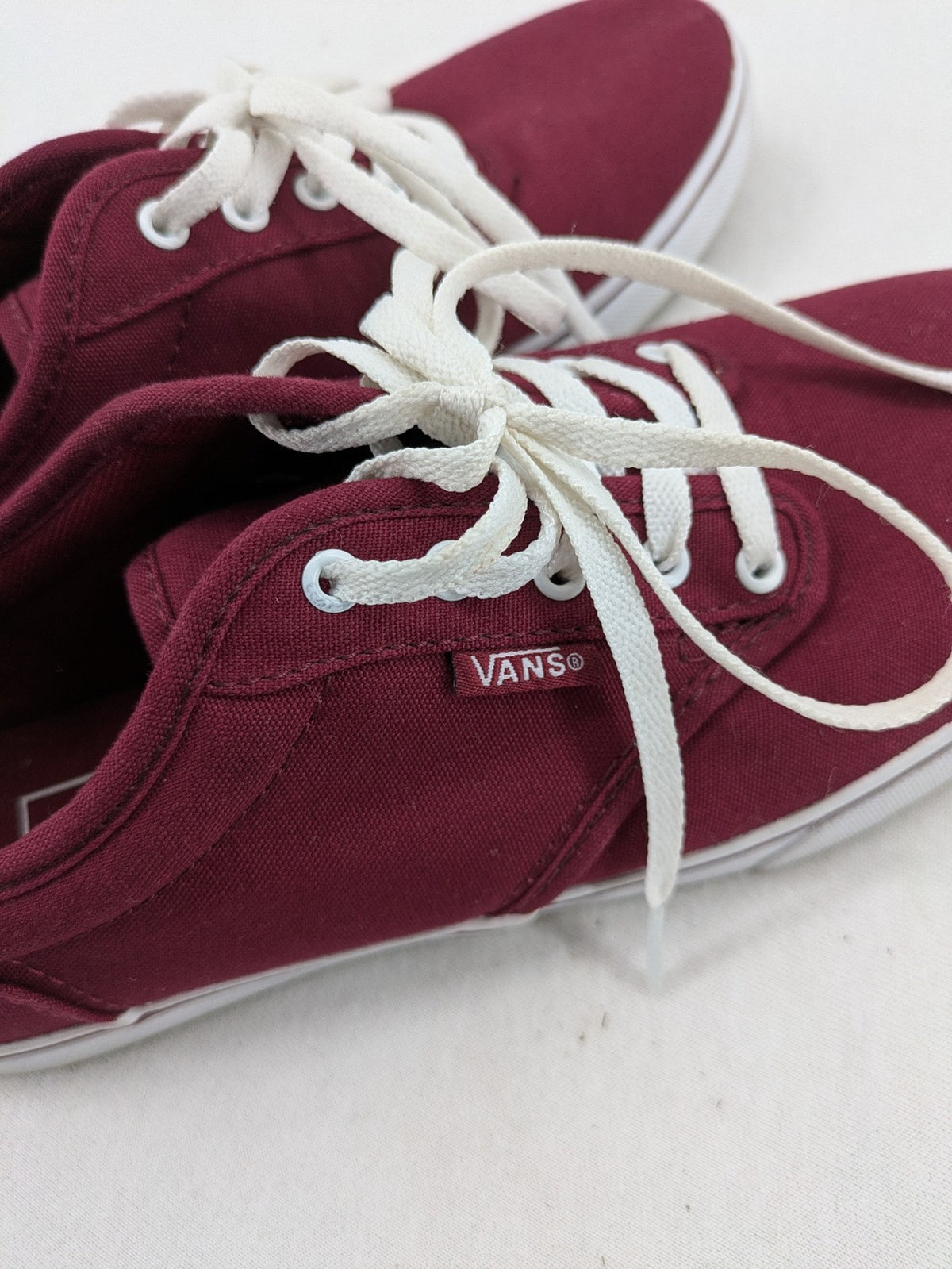 Vans low-top sneakers burgundy canvas with white logo and classic waffle sole.