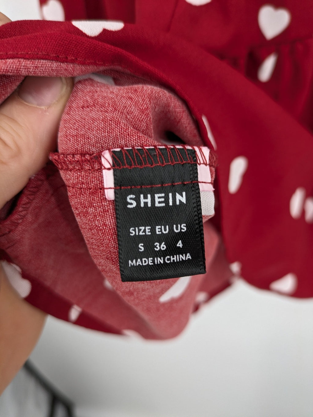 SHEIN burgundy top with white heart pattern and ruffled neckline detail.