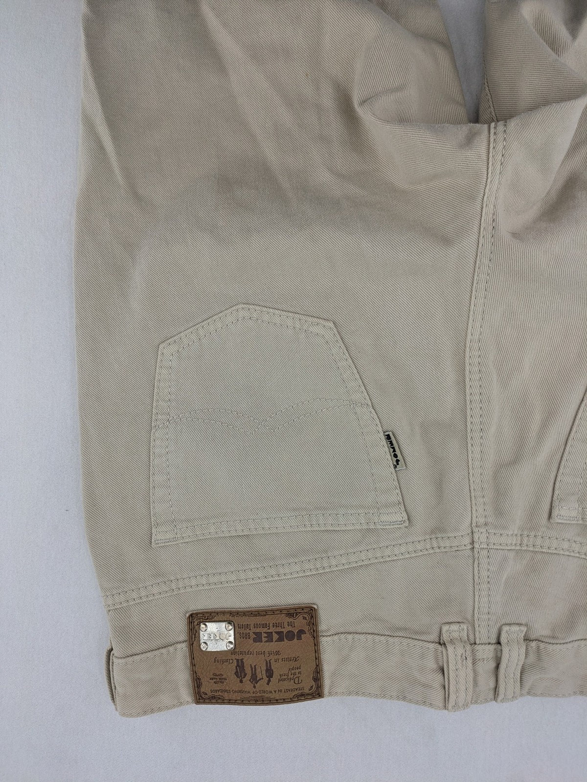 Joker beige straight jeans 5-pocket design with zipper and button closure.