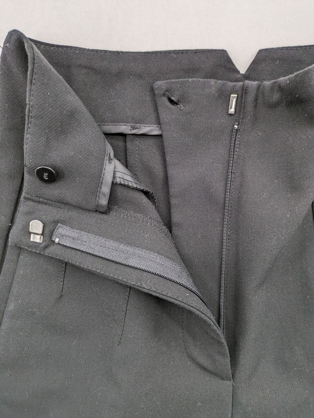 Zara black high-waist pants with concealed zipper, hook and button closure, elegant design.