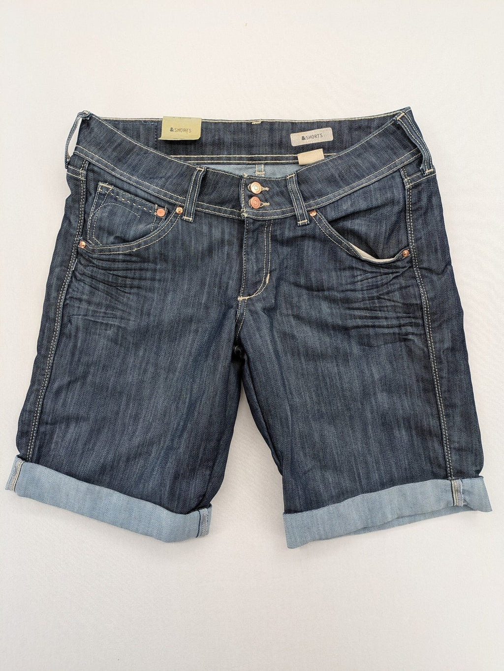 H&M blue denim shorts with rolled cuffs and back patch pockets, mid-rise fit.