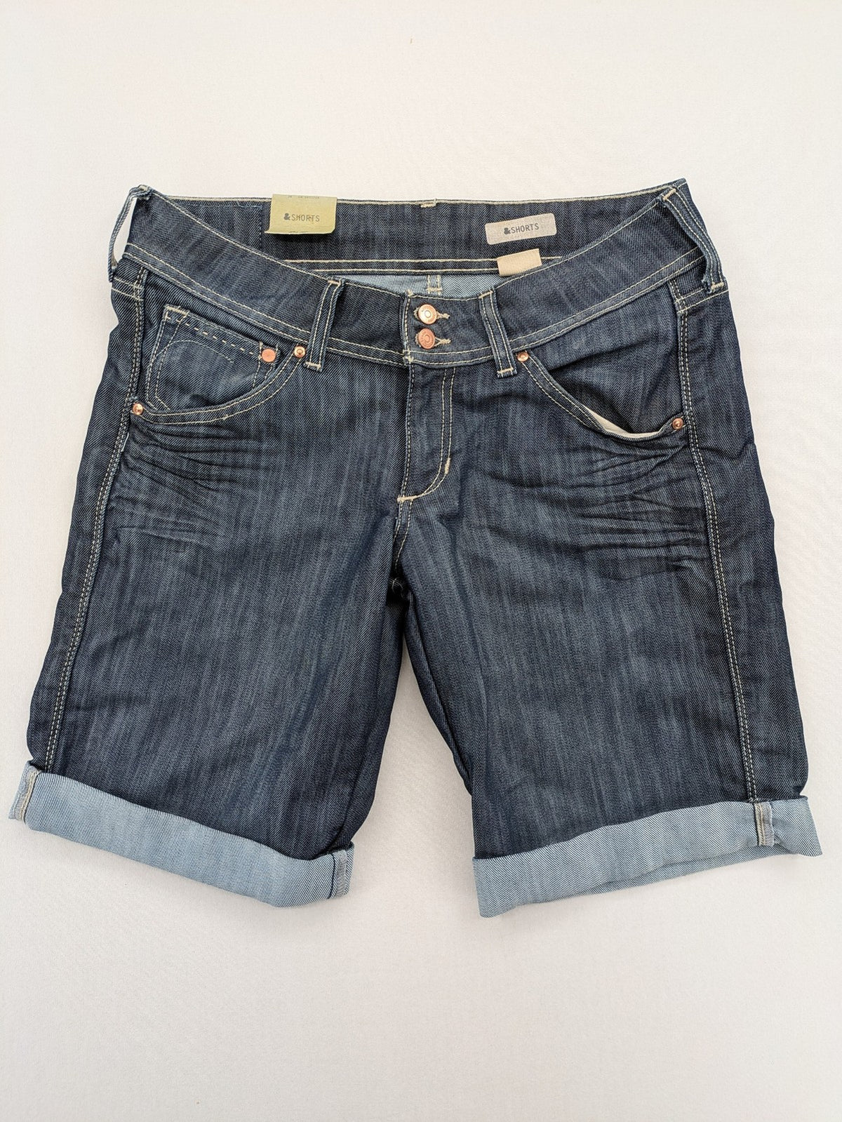 H&M blue denim shorts with rolled cuffs and back patch pockets, mid-rise fit.