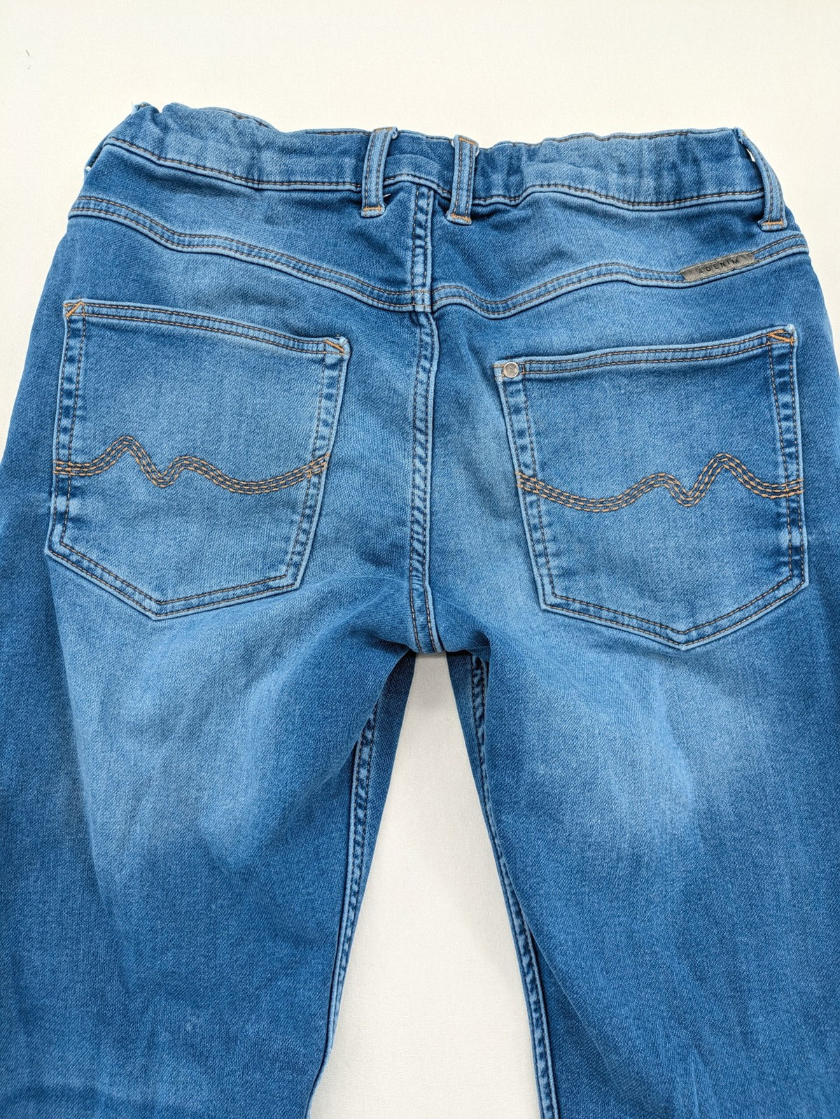 H&M blue straight jeans with elastic waistband and white drawstring, casual jogger style.