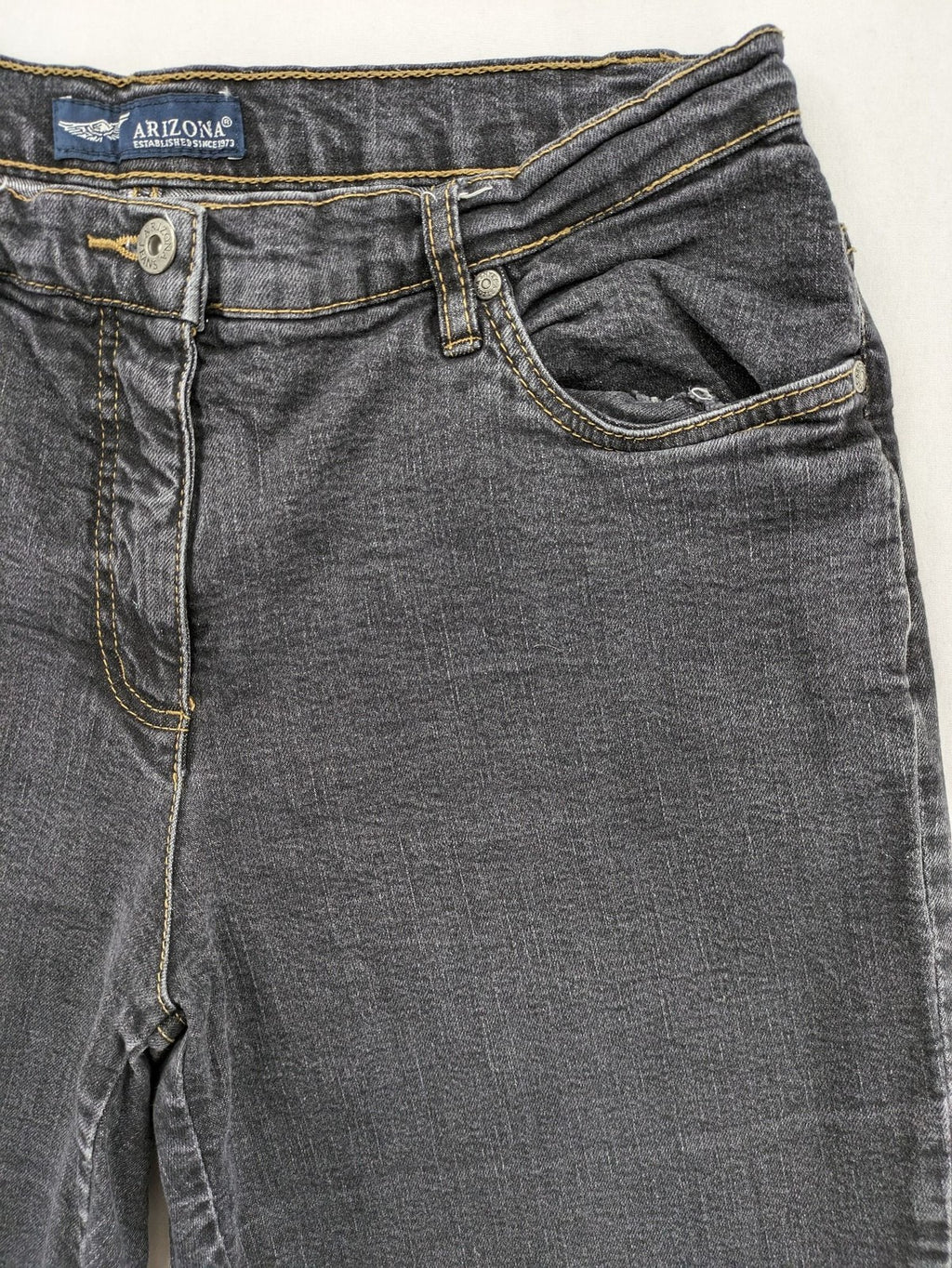 Bootcut grey low rise bootcut jeans five-pocket design with zipper and button closure.