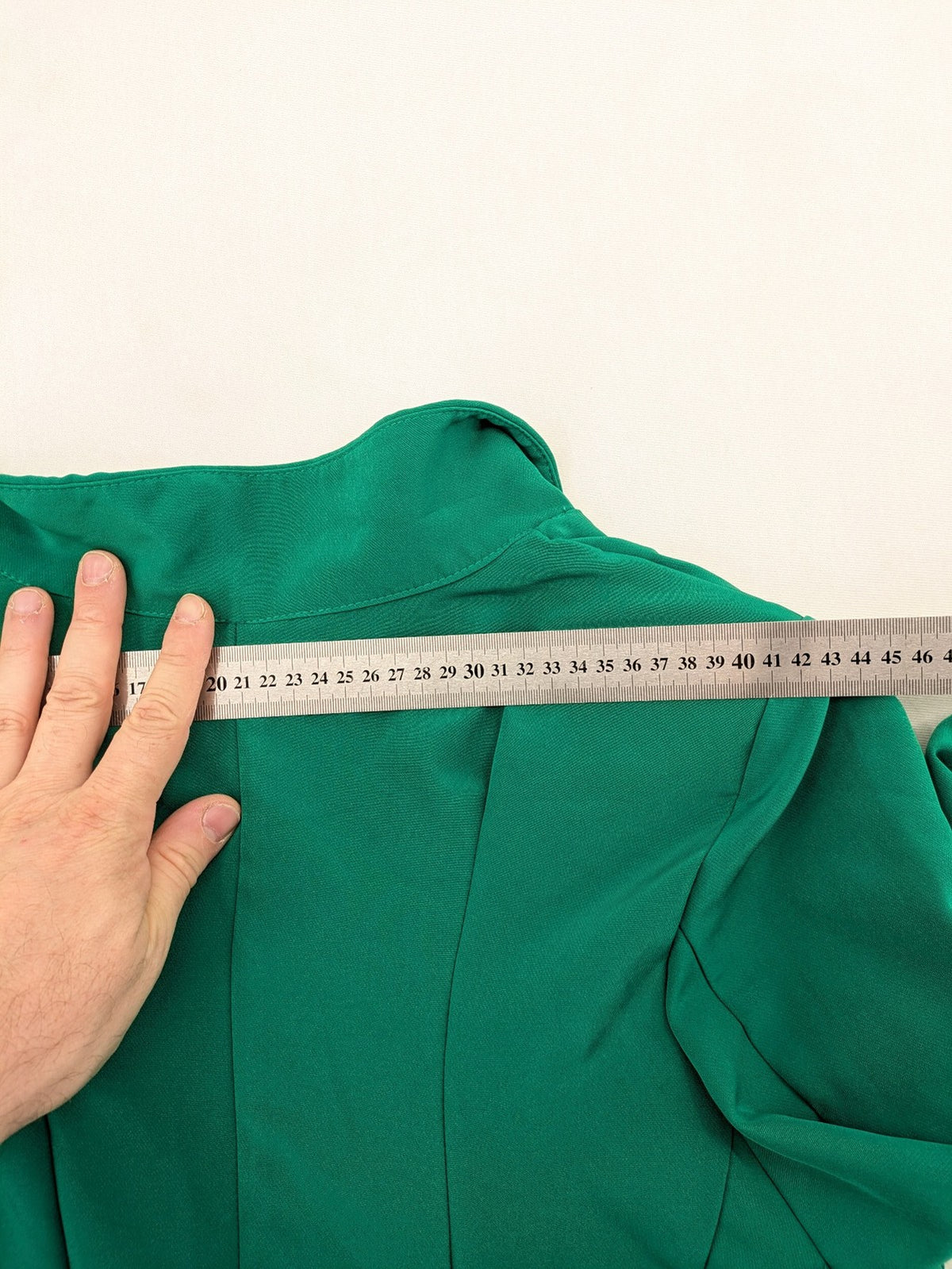 Promiss green blazer jacket single-button design with notch lapels and decorative pockets.