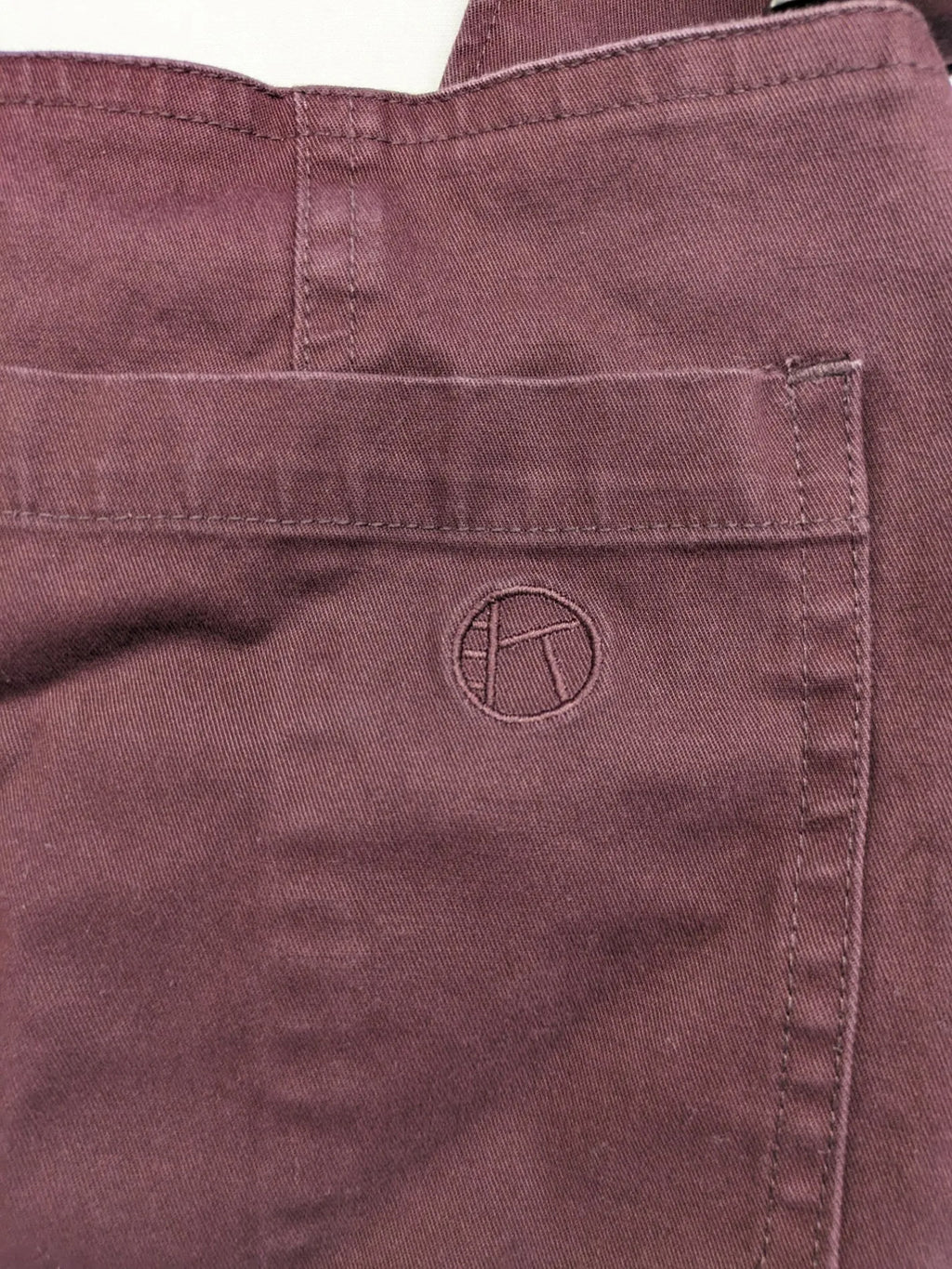 Kazane burgundy overalls with adjustable straps, side button placket, and chest pocket.