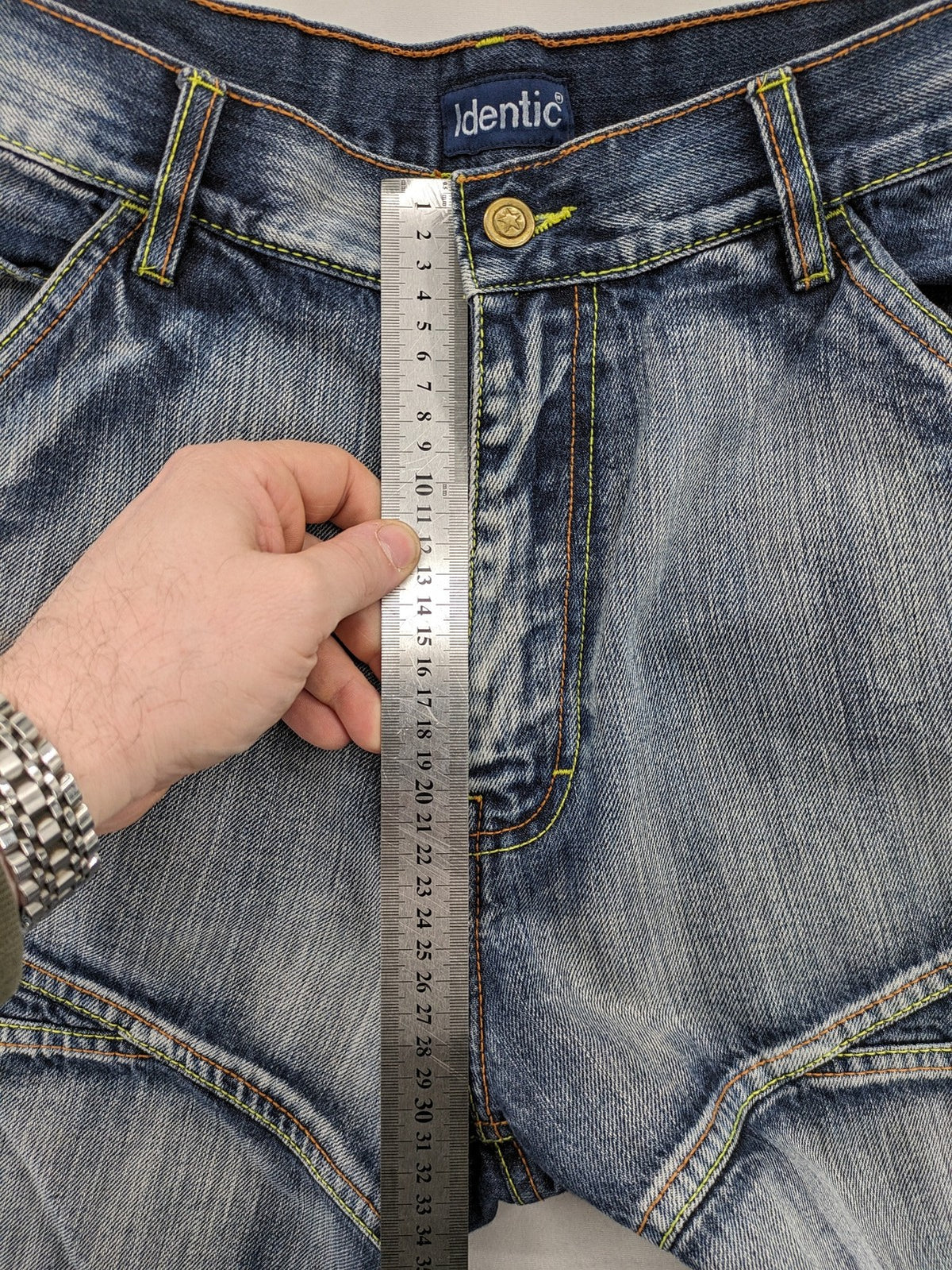 Identic orange straight jeans with paneled design and contrasting yellow stitching.