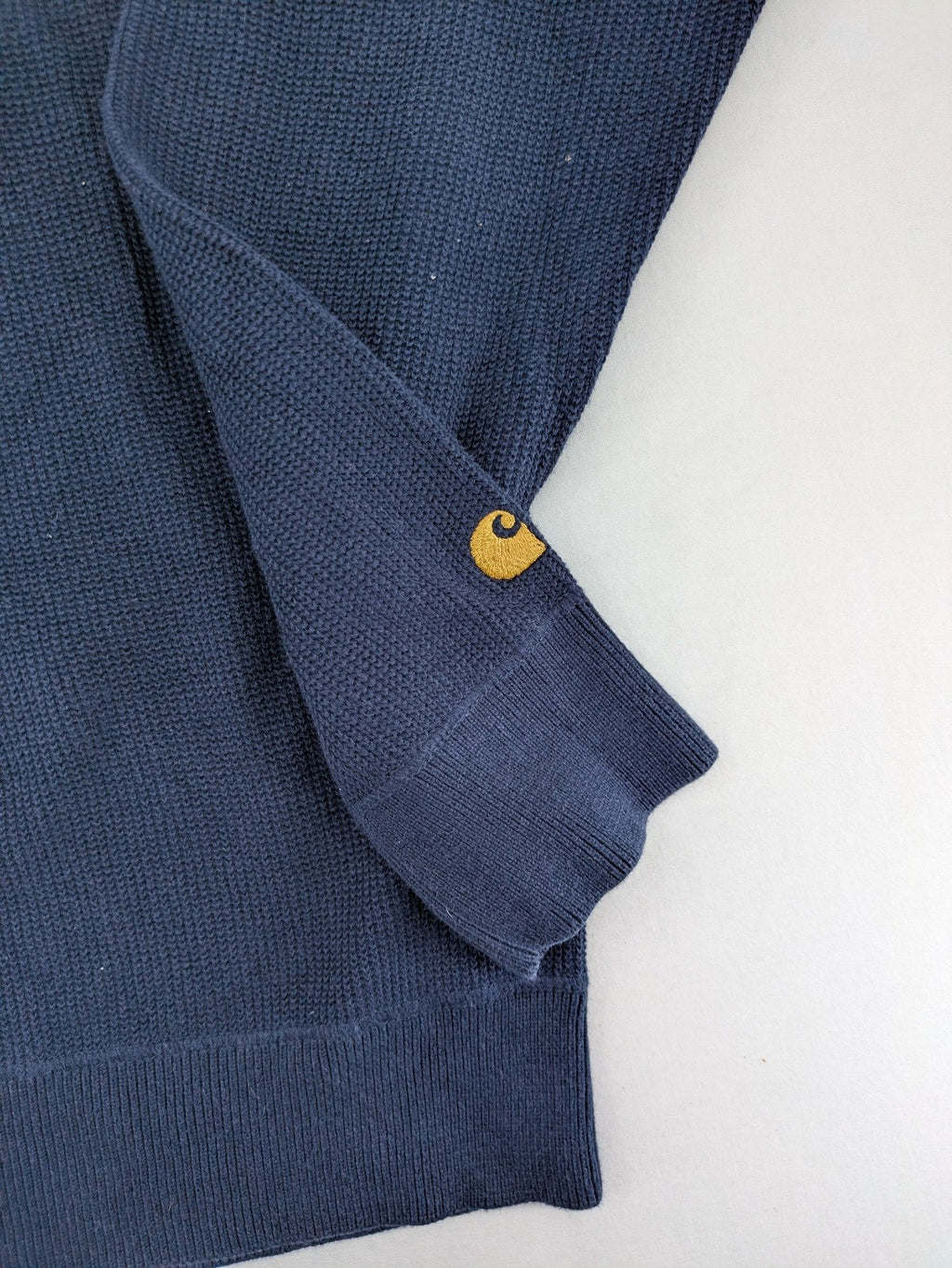 Carhartt navy turtle neck jumper waffle knit texture with subtle logo on sleeve.