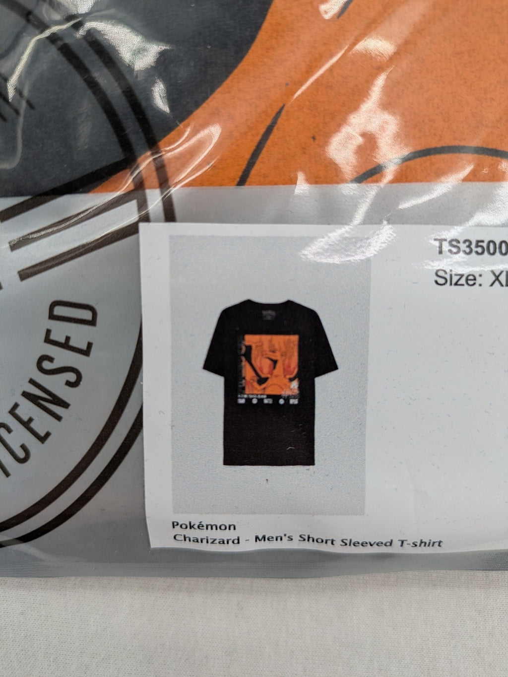 Herren orange T-Shirt mit großem Glurak Grafikdesign auf schwarzem Hintergrund.