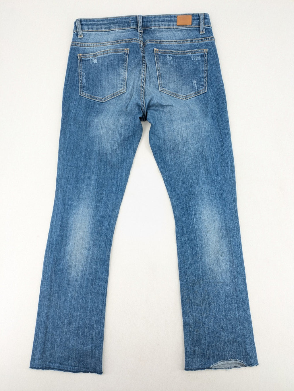 Tally Weijl blue bootcut jeans with distressed knees and raw hem detail.