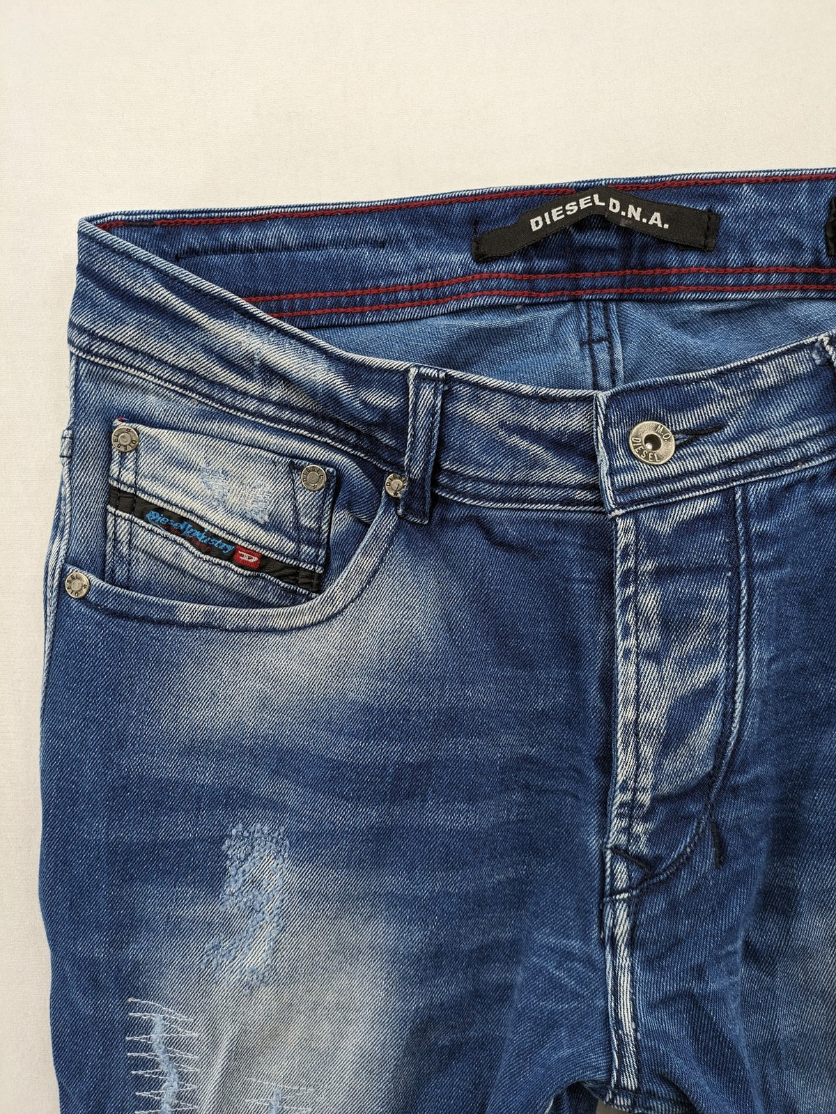 Diesel blue straight jeans with distressed details and ripped accents, made of cotton.