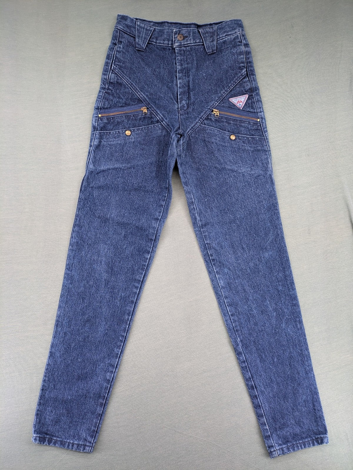 YKK blue high waist mom jeans with decorative front zipper pockets and vintage denim texture.