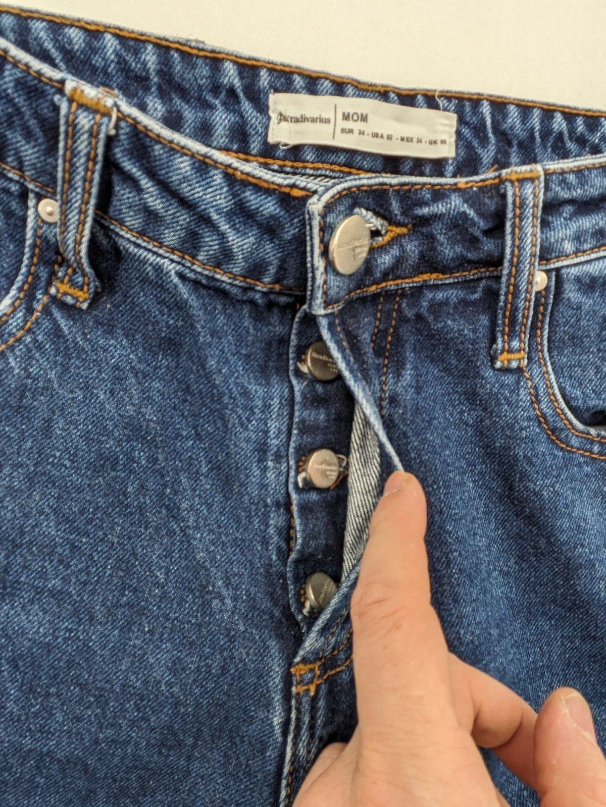 Stradivarius blue mom jeans high waist with button fly and classic denim texture.